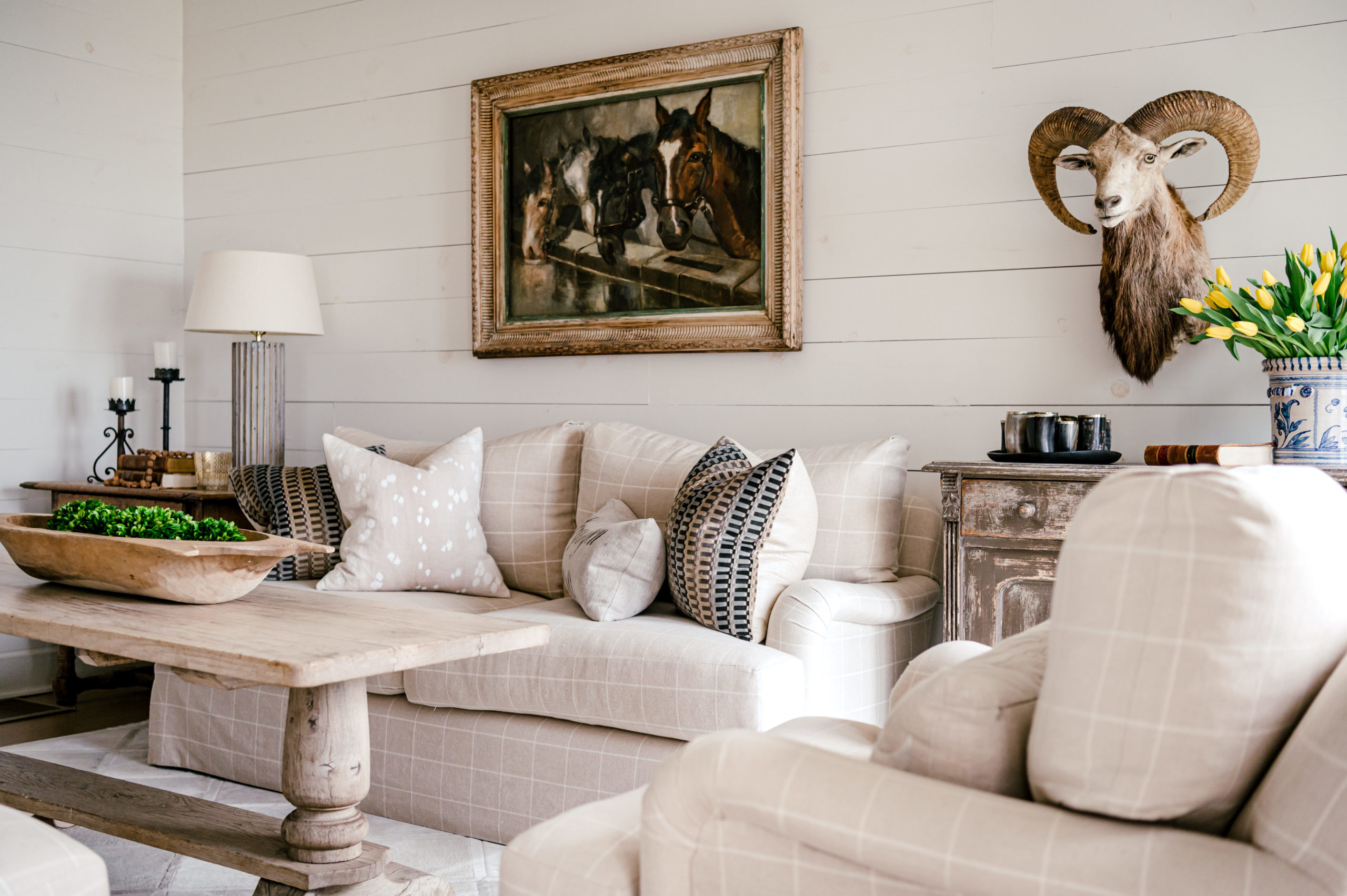 Interior Photography of white striped couches and pillows and wall decor 