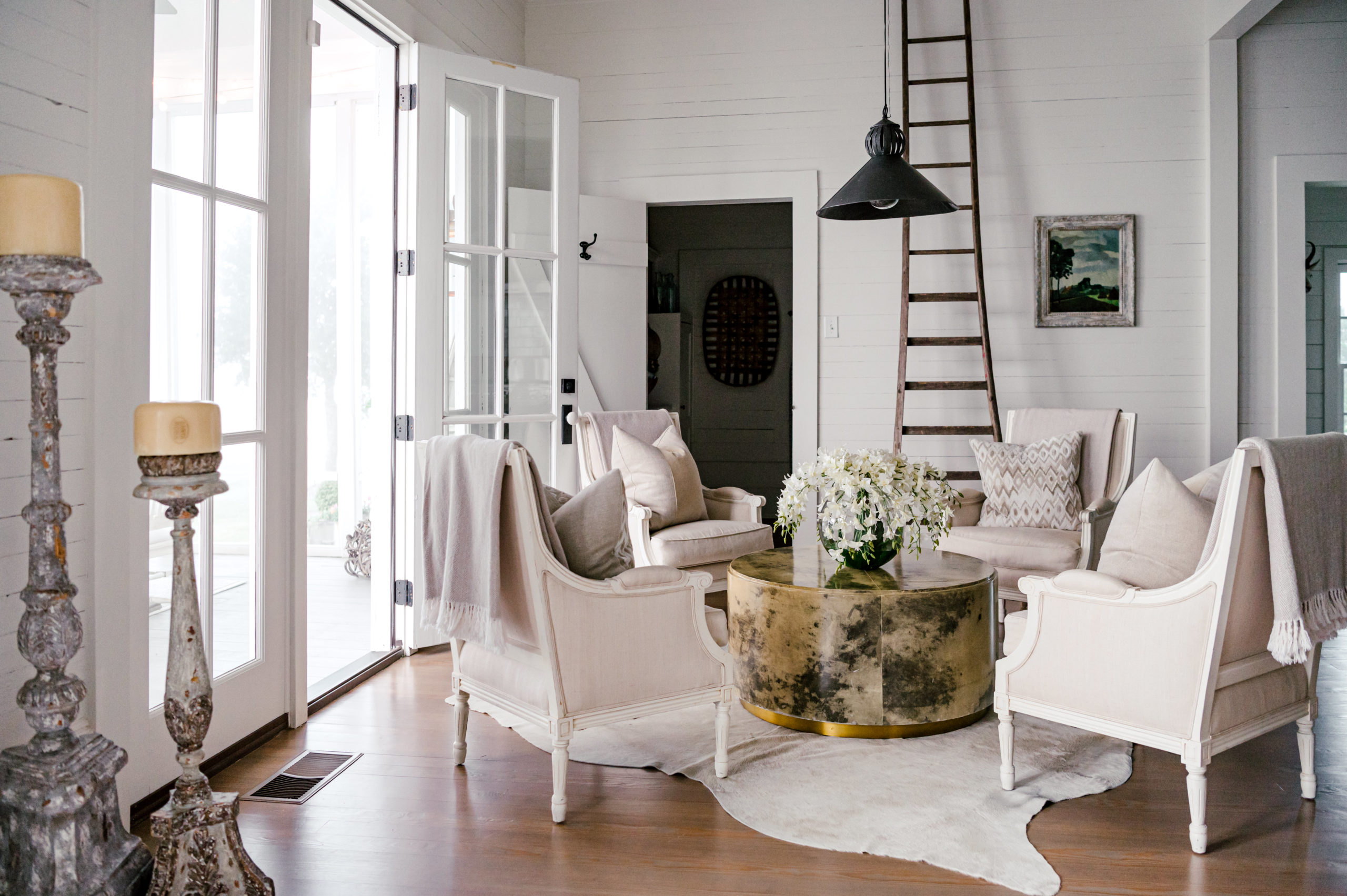 Interior Photography of lounge area with four white love chairs and gold and black stone table  