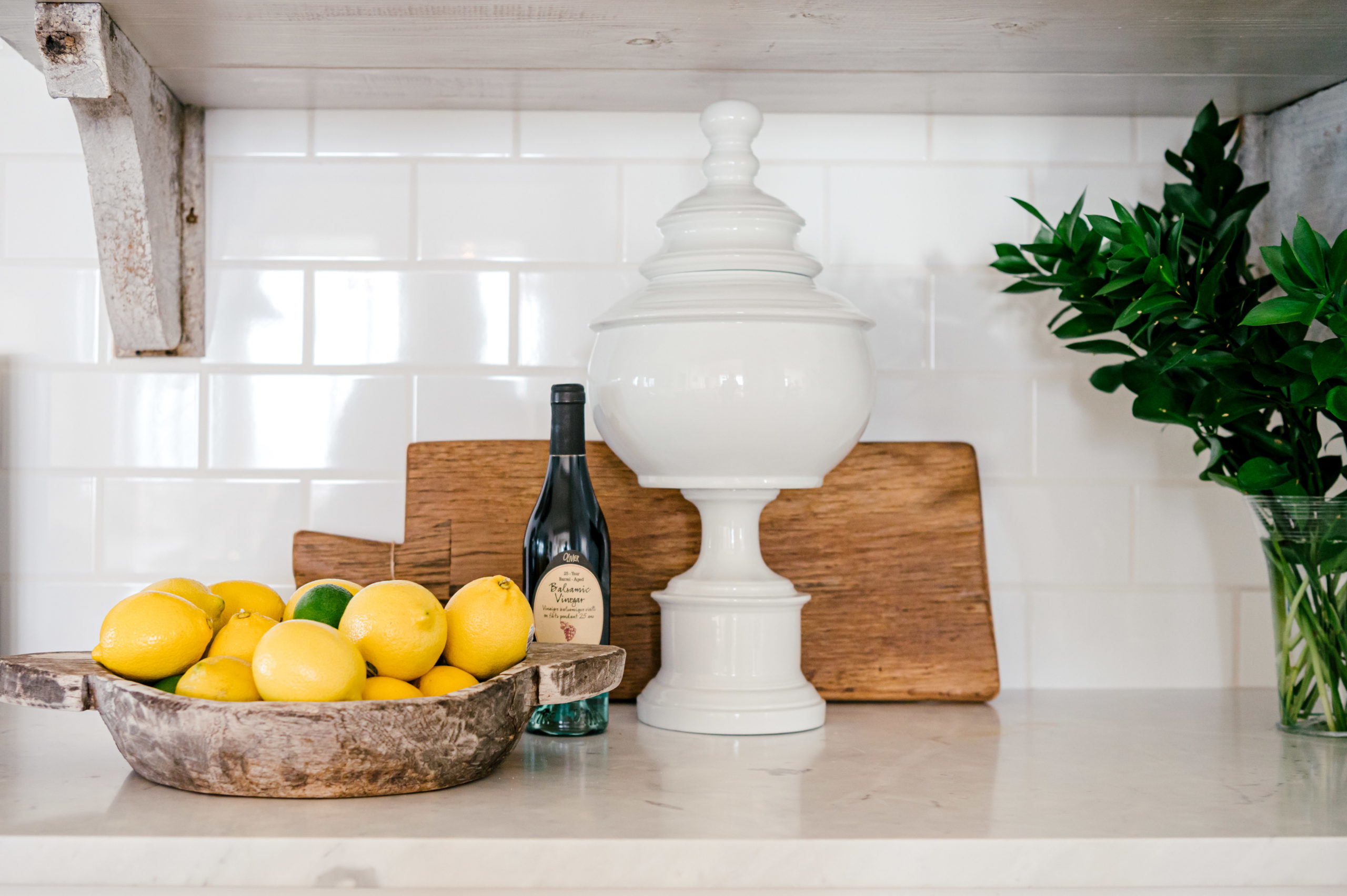 Interior Photography of kitchen counter with lemons and cutting boards with backsplash white subway tiles
