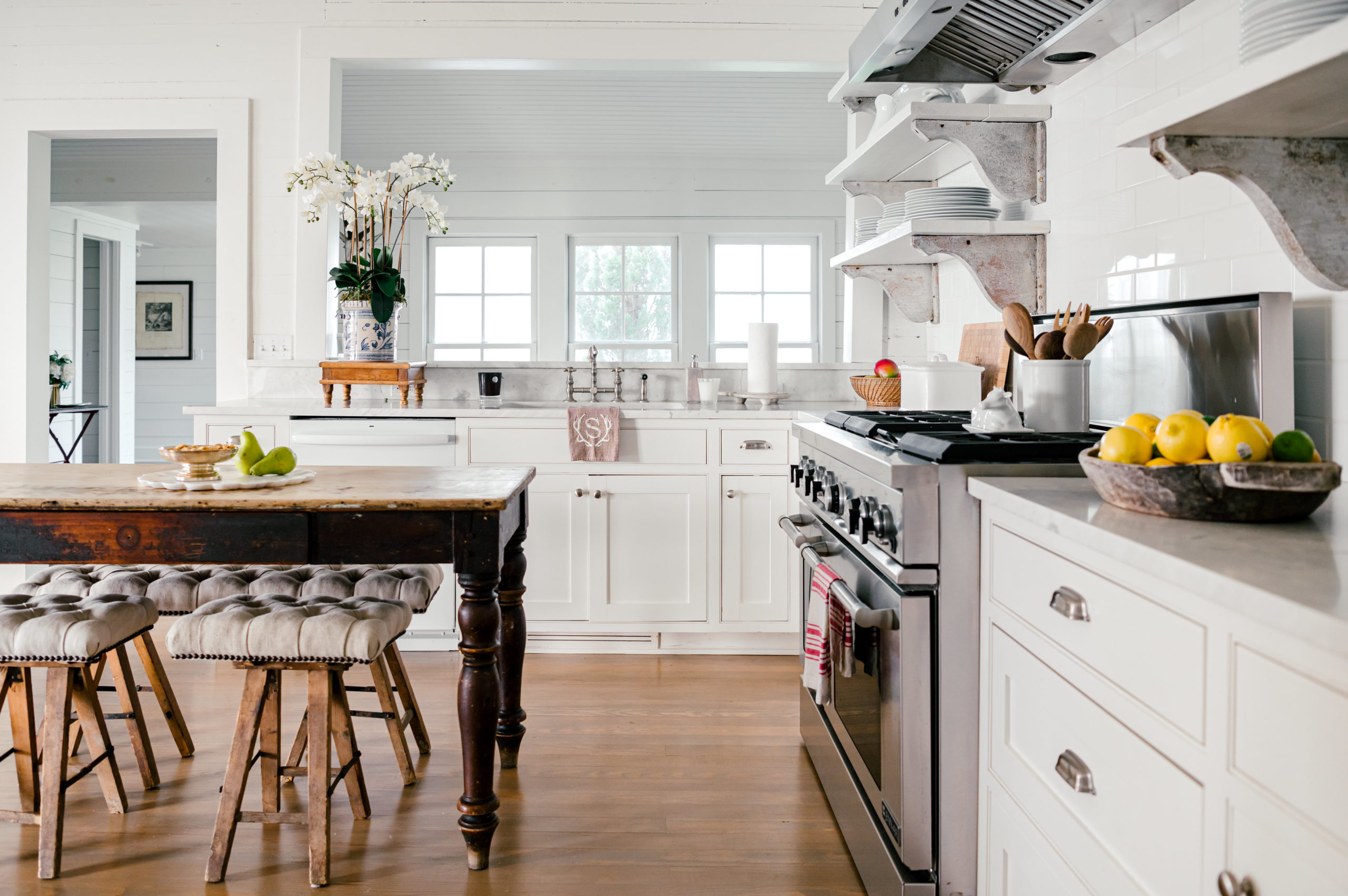 Interior Photography of a beautiful Farm house kitchen with white cabinets and a wooden island and chairs