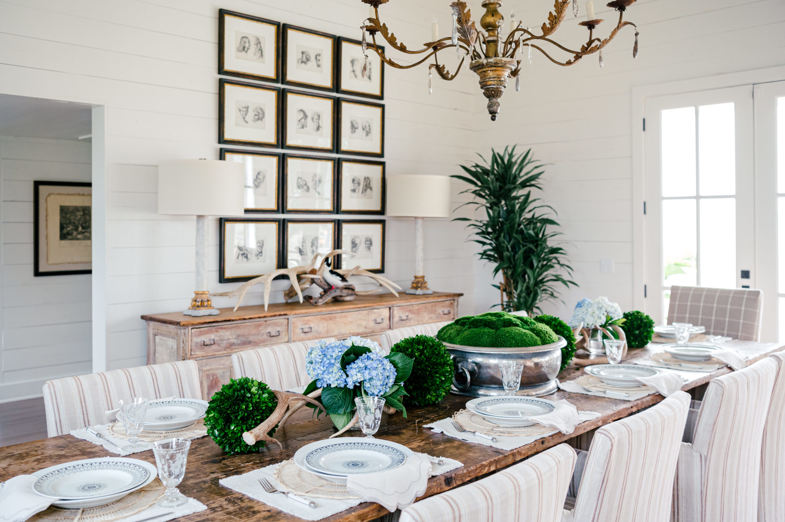 Interior Photography of dining room with a gorgeous wooden dining room table set with beautiful china and faux plants