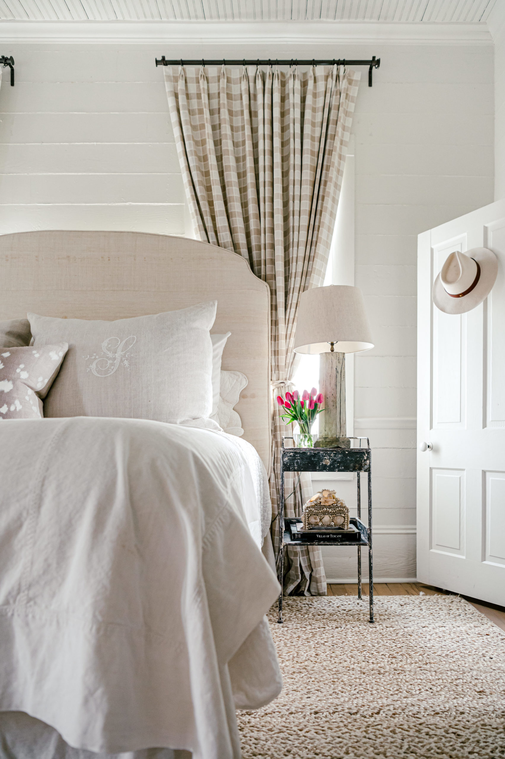 Interior Photography of bedroom with a beautiful bed with white linens and a black side table 