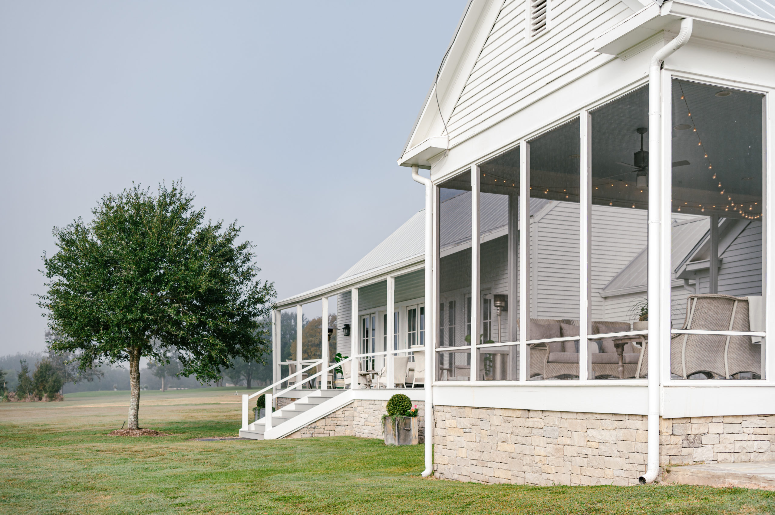 Photo of exterior of a beautiful white farmhouse 
