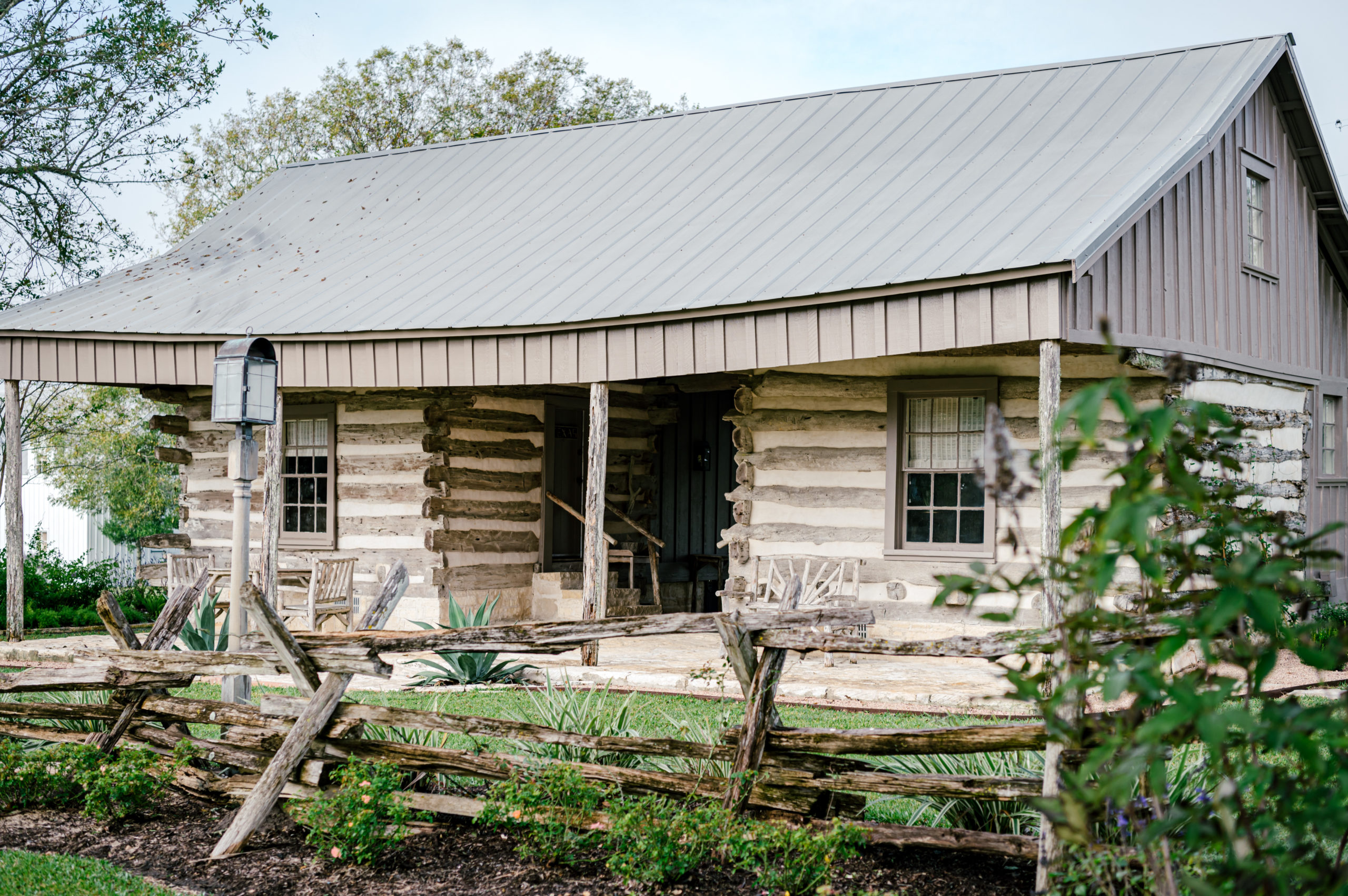 Photo of beautiful farmhouse exterior with wooden fences