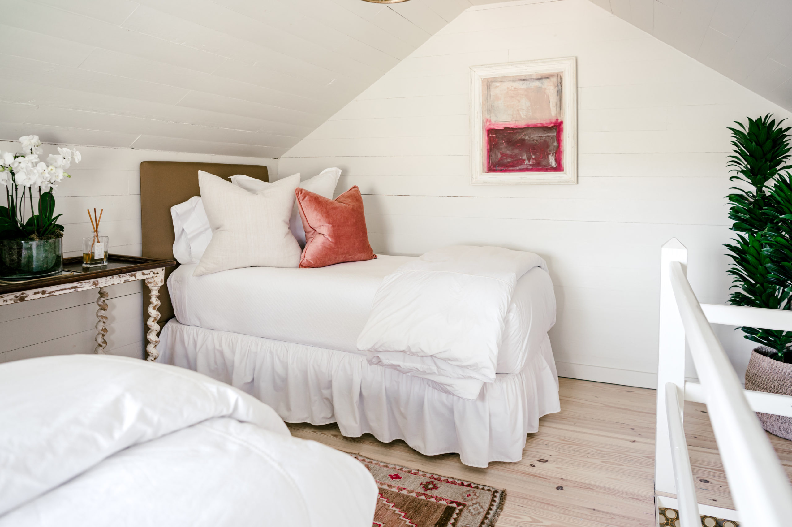 Photo of bedroom with white twin and white and pink pillows