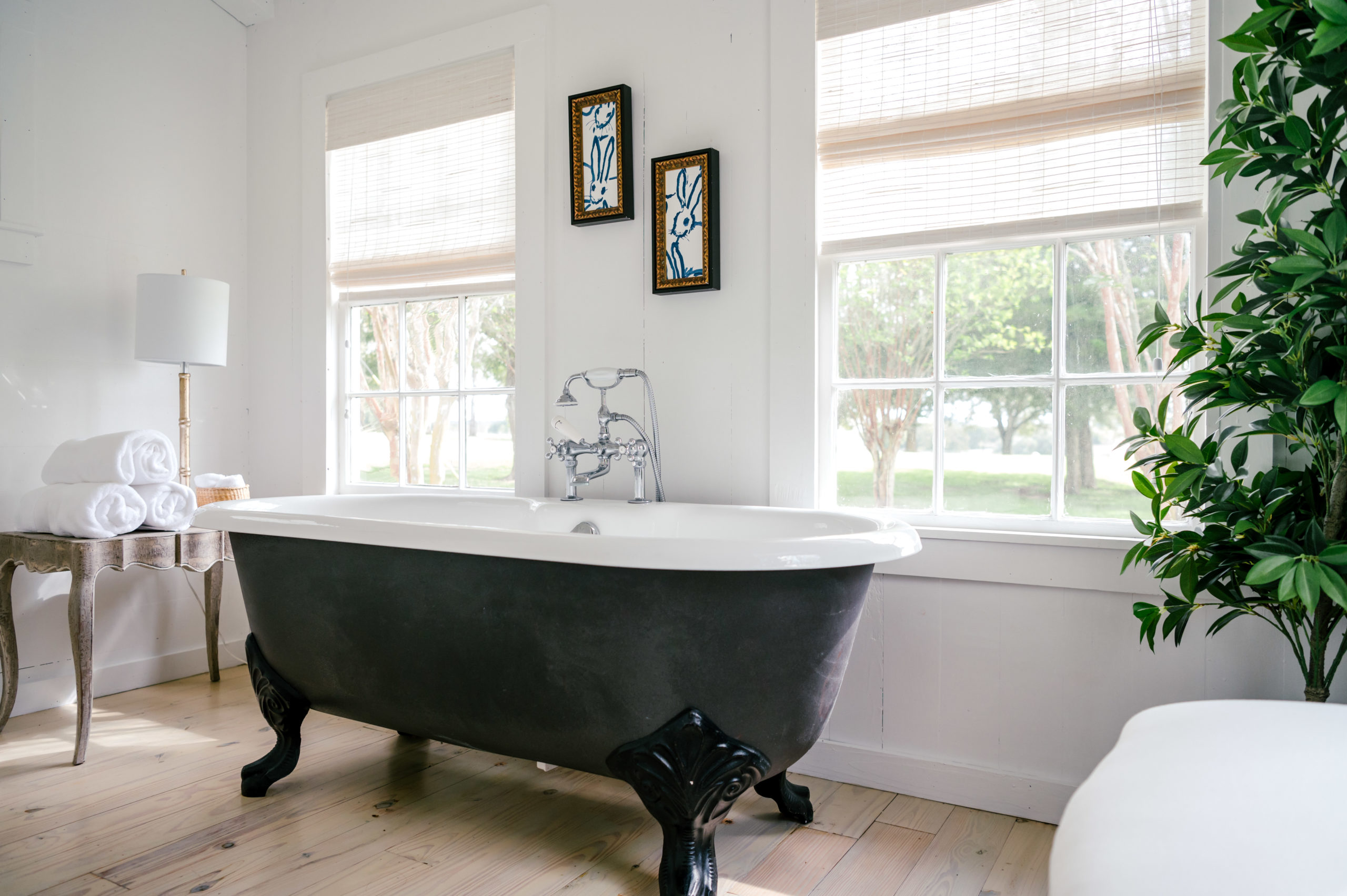 Interior Photography of beautiful farmhouse bathroom with a black and white Cast Iron Soaking Clawfoot Tub