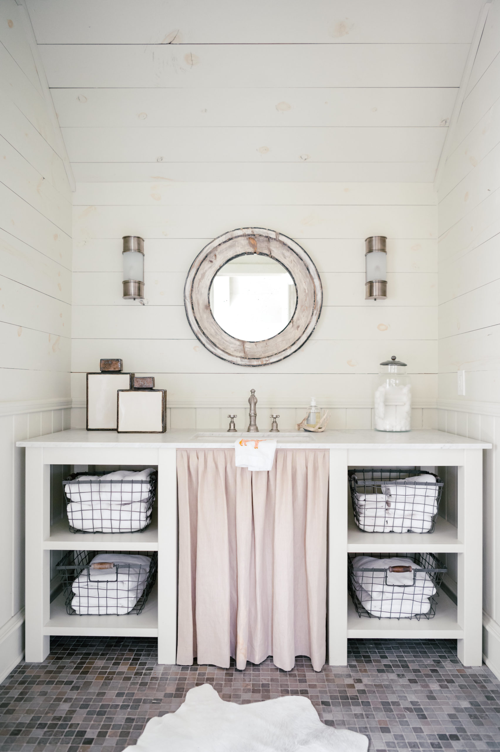 Photo of farmhouse bathroom with gray tiles and white sink and cabinets