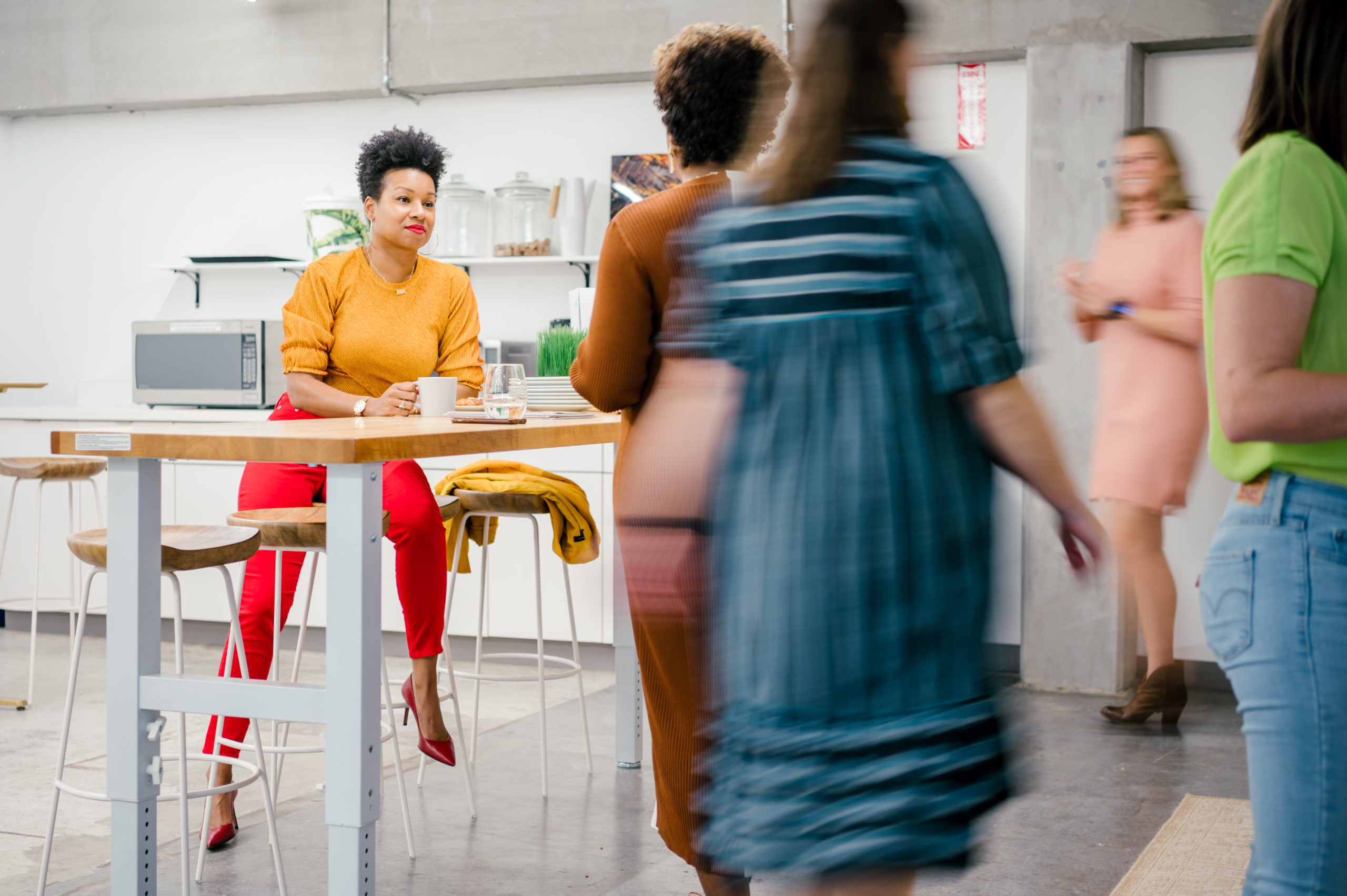 Photo of women of Sesh coworking walking and talking in the office kitchen 