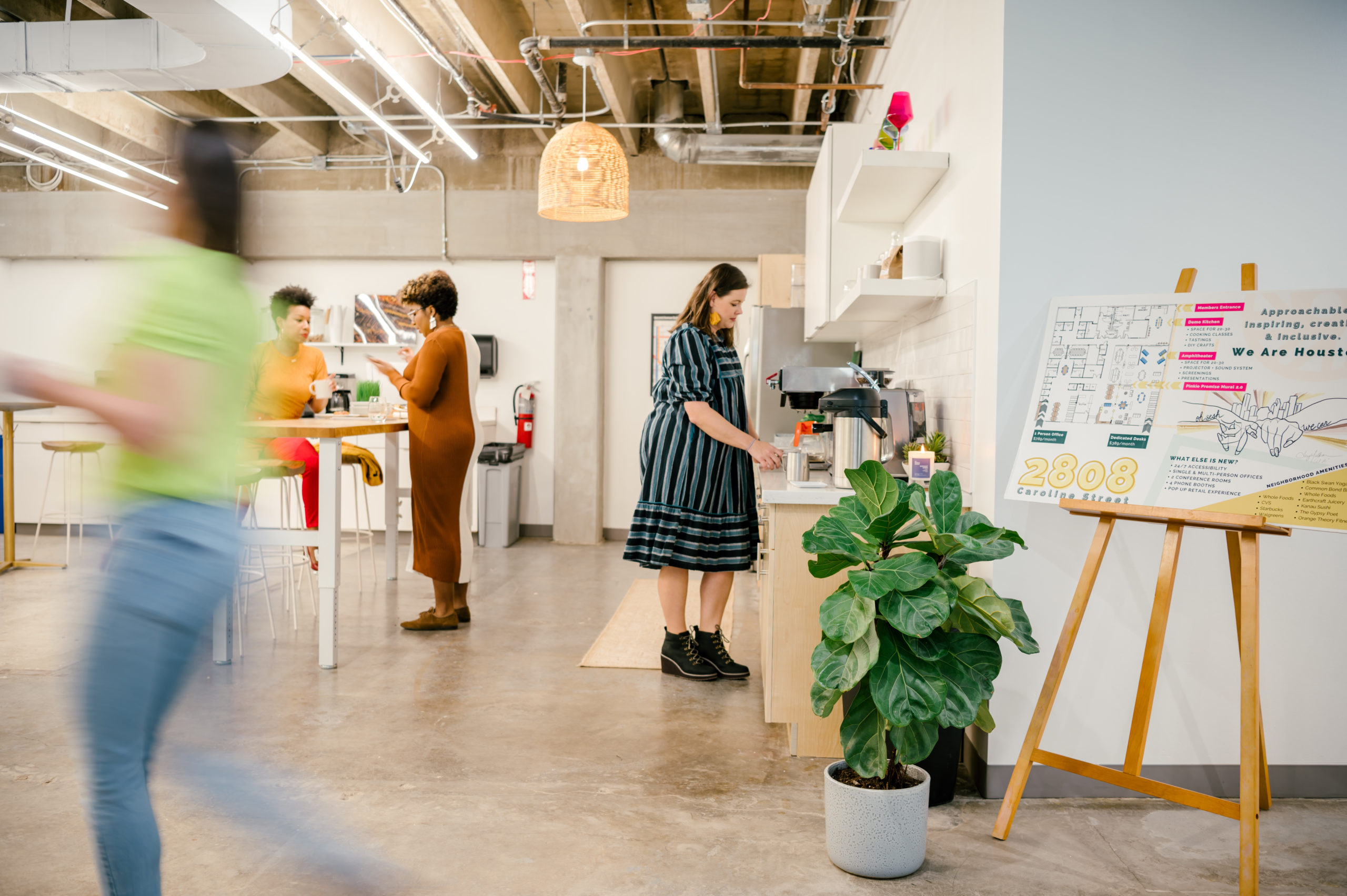 Photo of women of Sesh coworking walking and talking in the office kitchen 