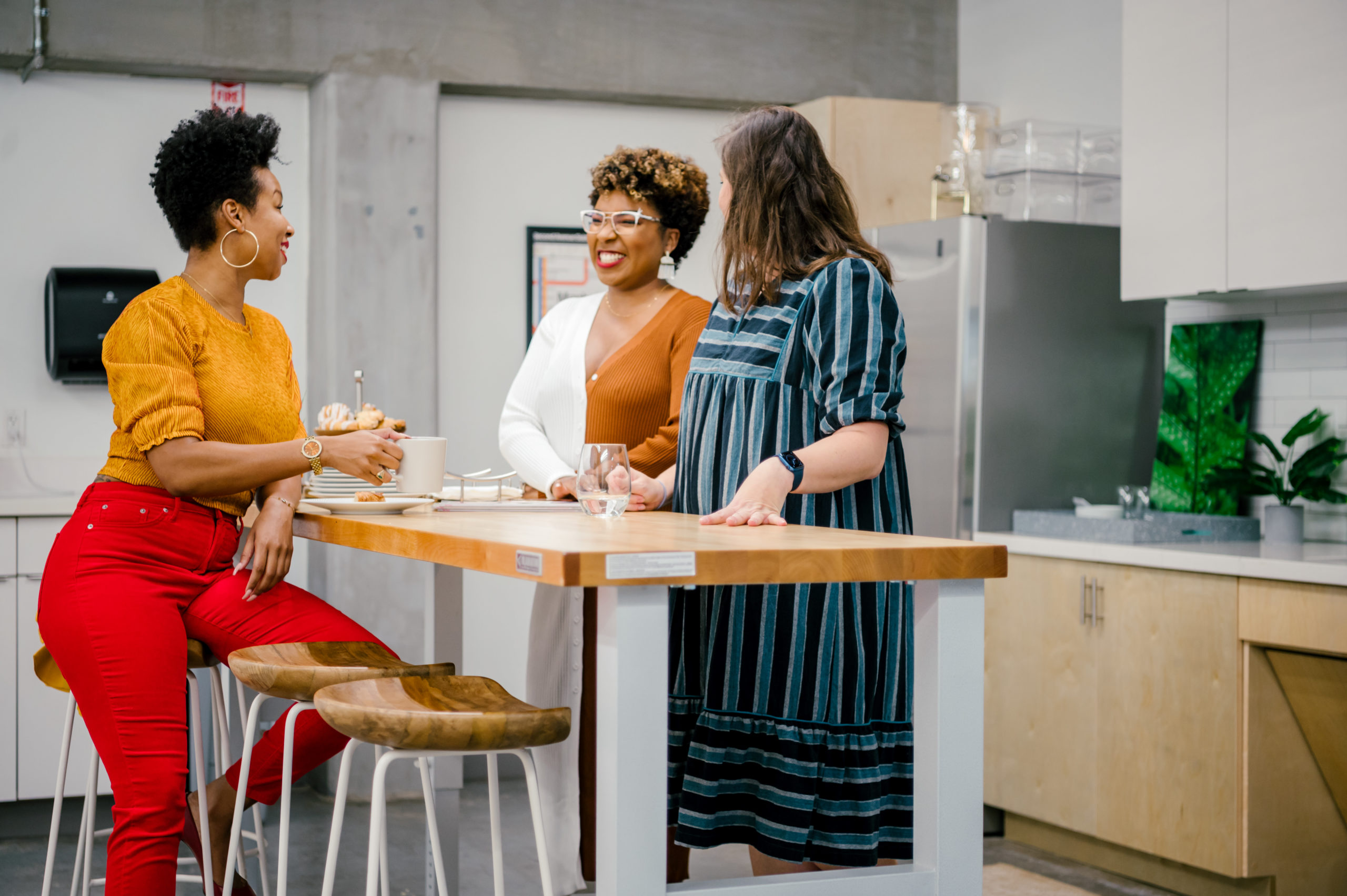 Personal Brand Photography of women of Sesh coworking laughing and talking in the office kitchen