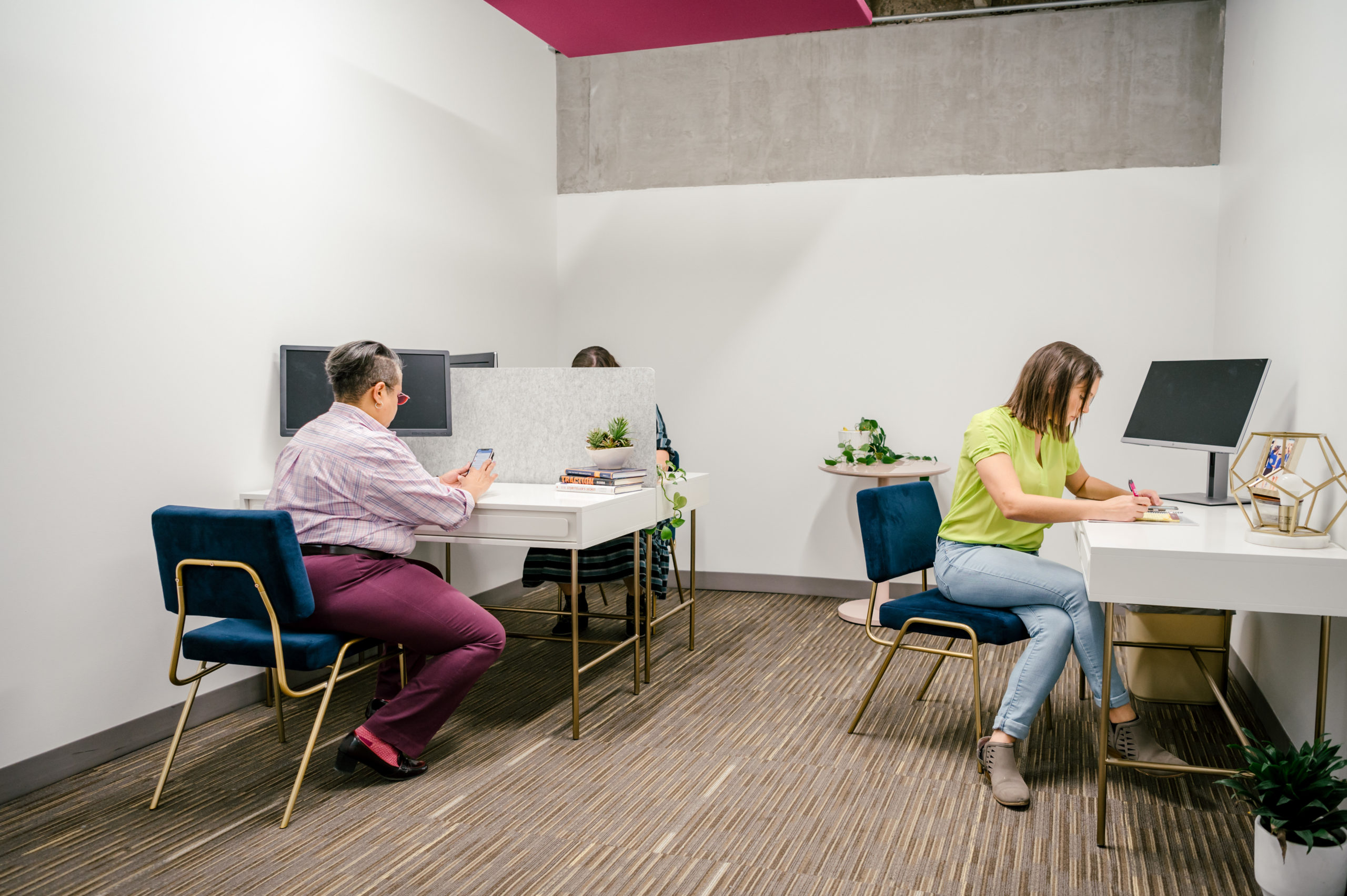 Photo of office community workspace with women sitting at desks working