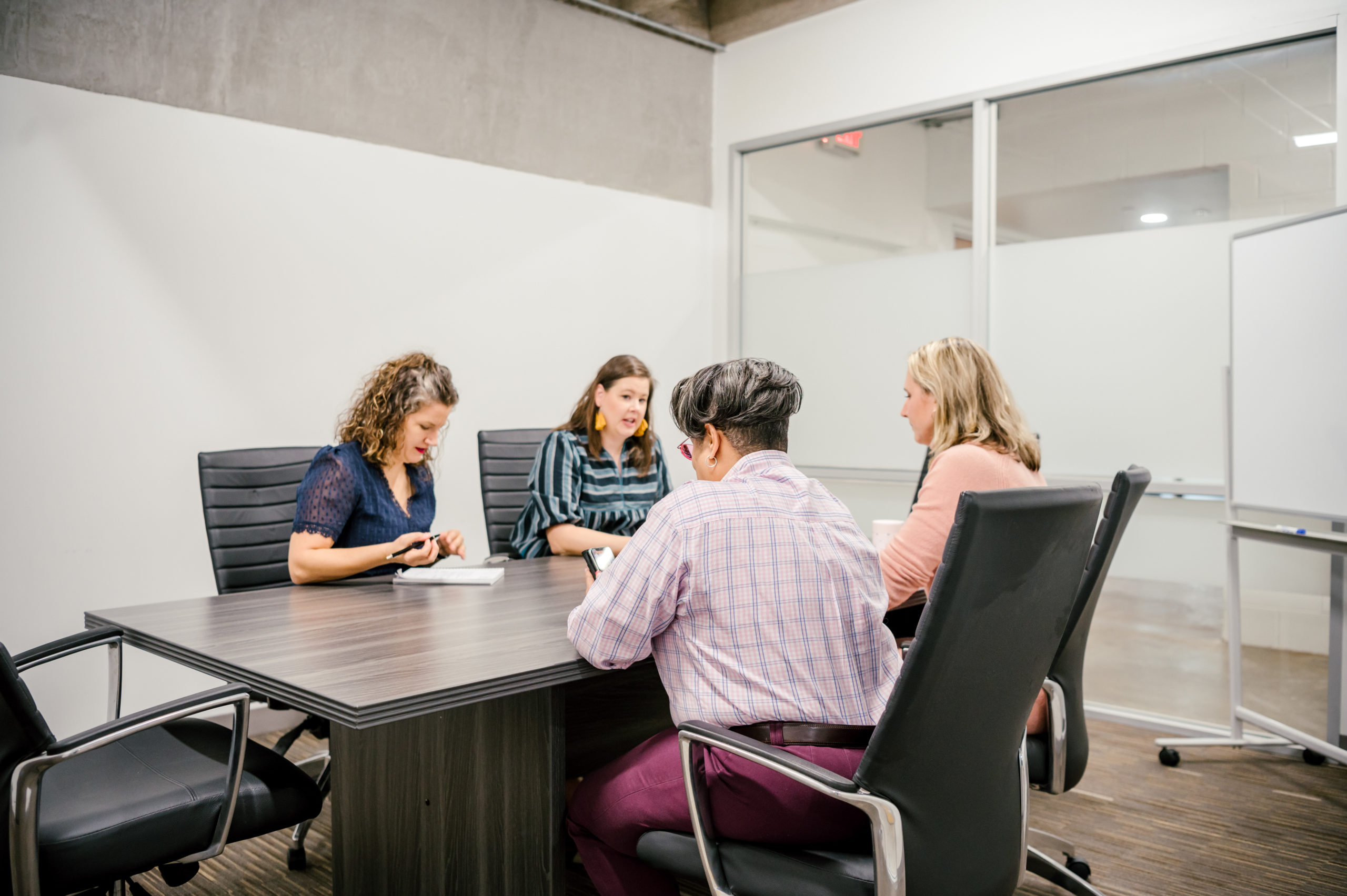 Personal Brand Photography of women in a workspace sitting at a longe desk having a work meeting