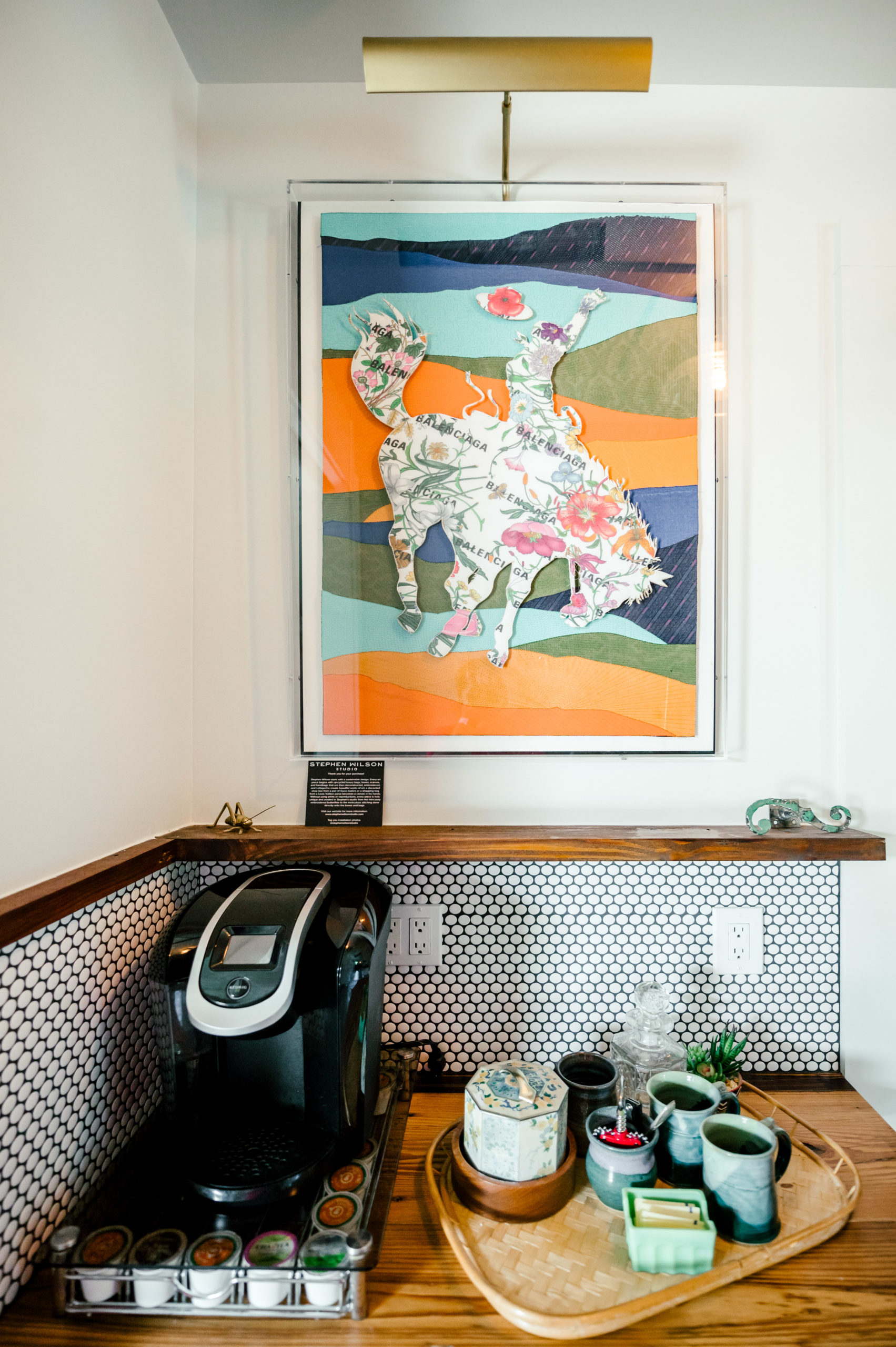 Coffee station with a coffee maker and western art hanging on the wall