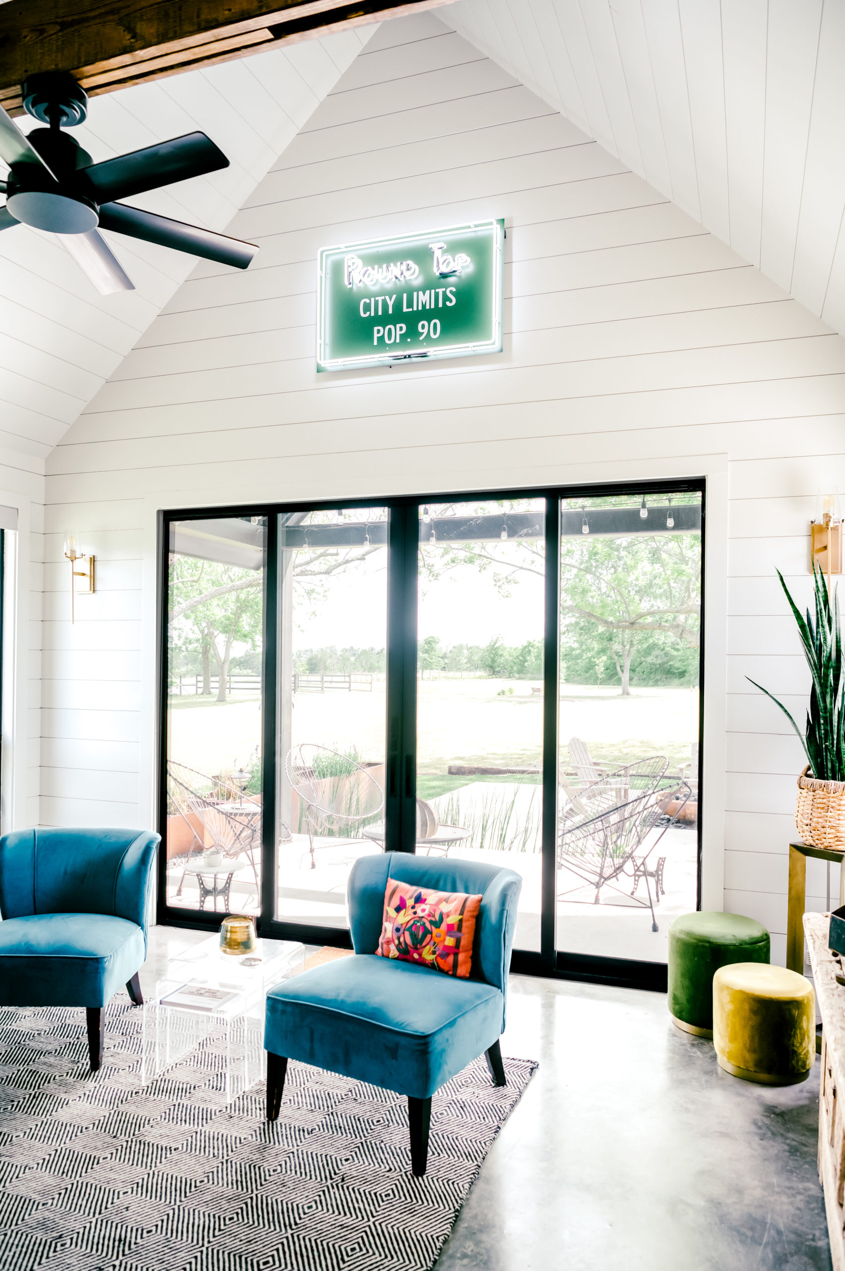 Two velvet love seats sitting in the living room in front of the sliding glass door 