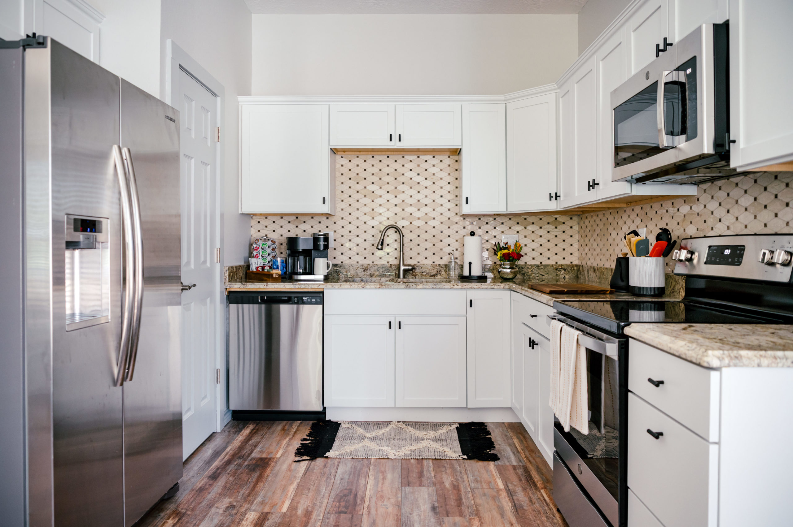 Interior Design Photography of Modern Kitchen interior design, stainless steel fridge and hardwood flooring with marble kitchen counters