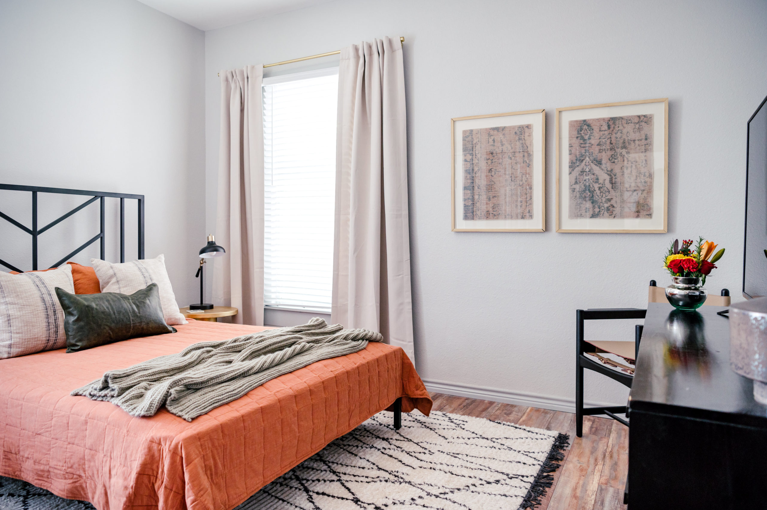 Interior Design Photography of Bedroom interior with queen bed made with an orange comforter and pillows