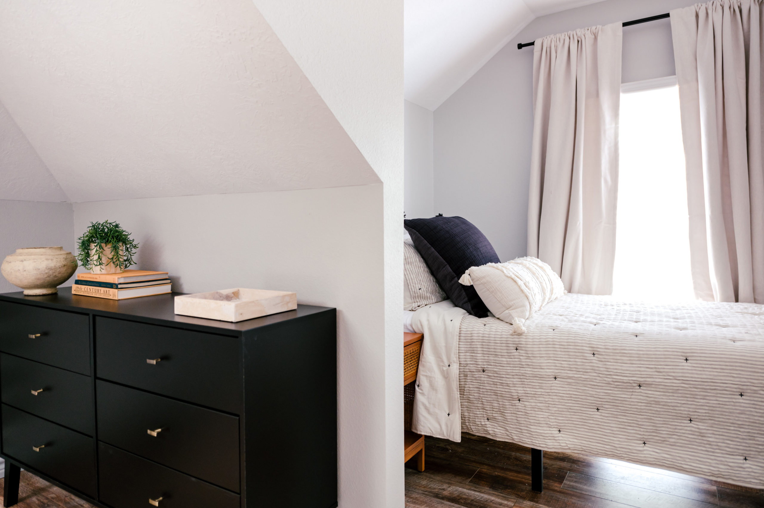 Twin sized bed with white comforter and black dresser