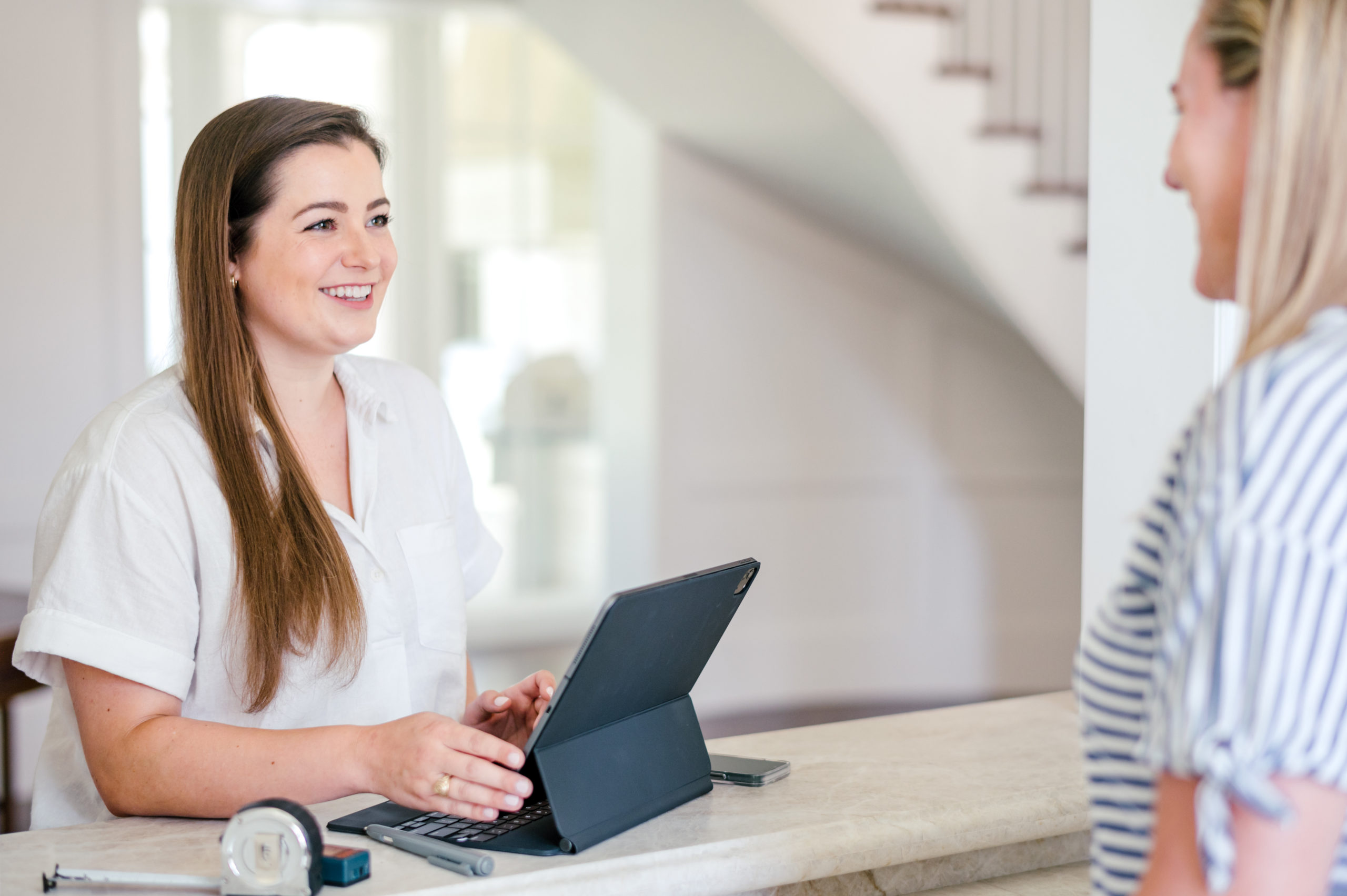 Photo of a Woman talking to client while using iPad Houston Brand Photographer