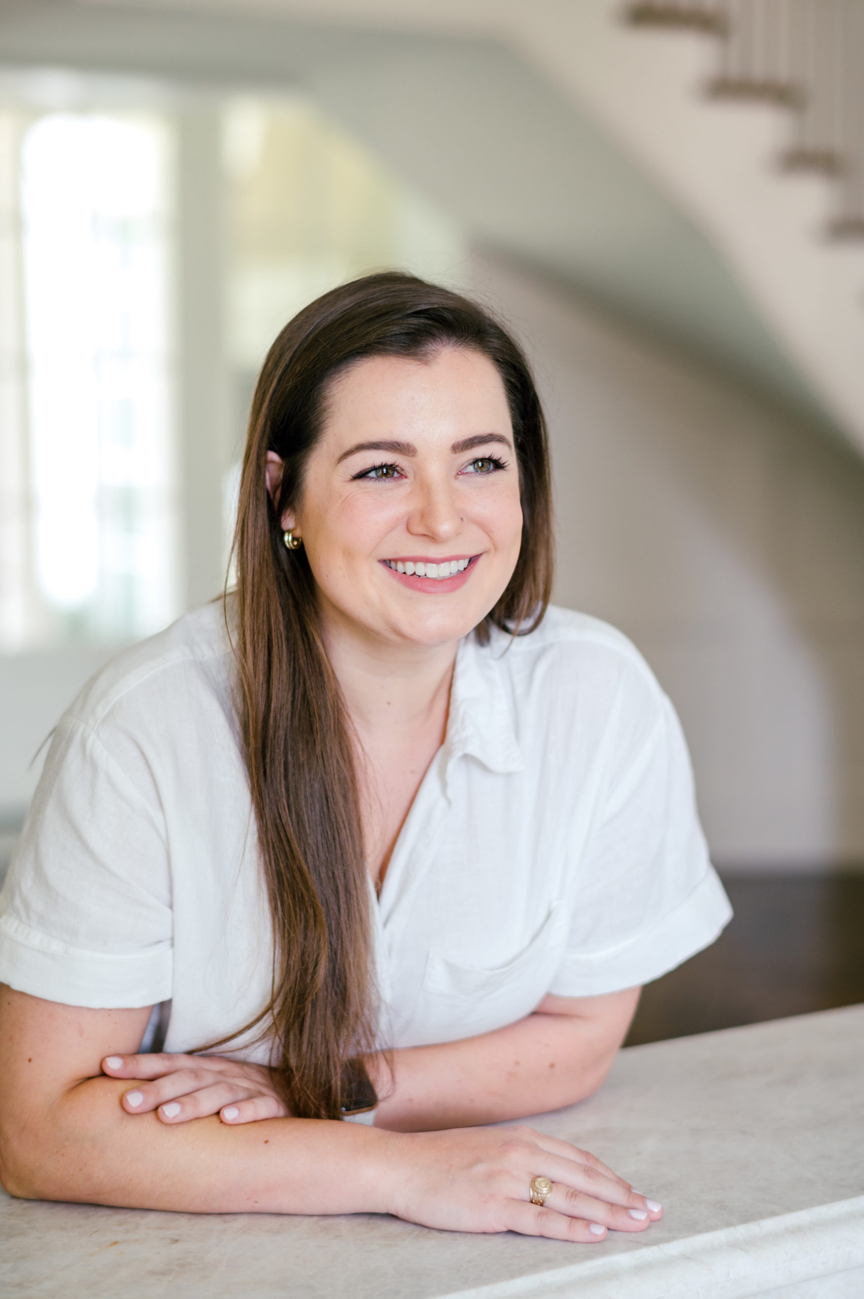 Photo of a Woman smiling off into the distance wearing a white short sleeve button up Houston Brand Photographer