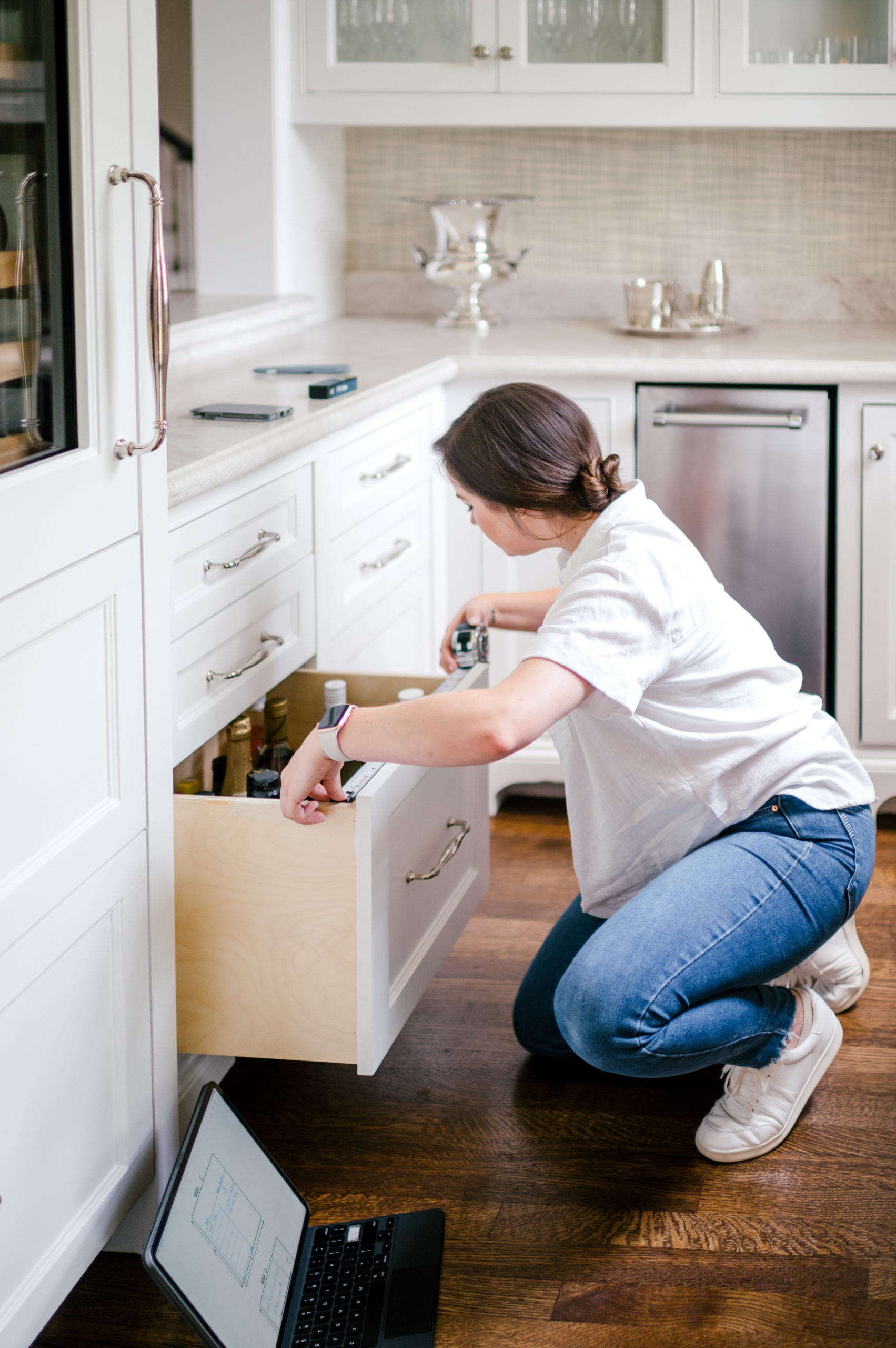 Woman organizing kitchen drawer full of alcoholic beverages