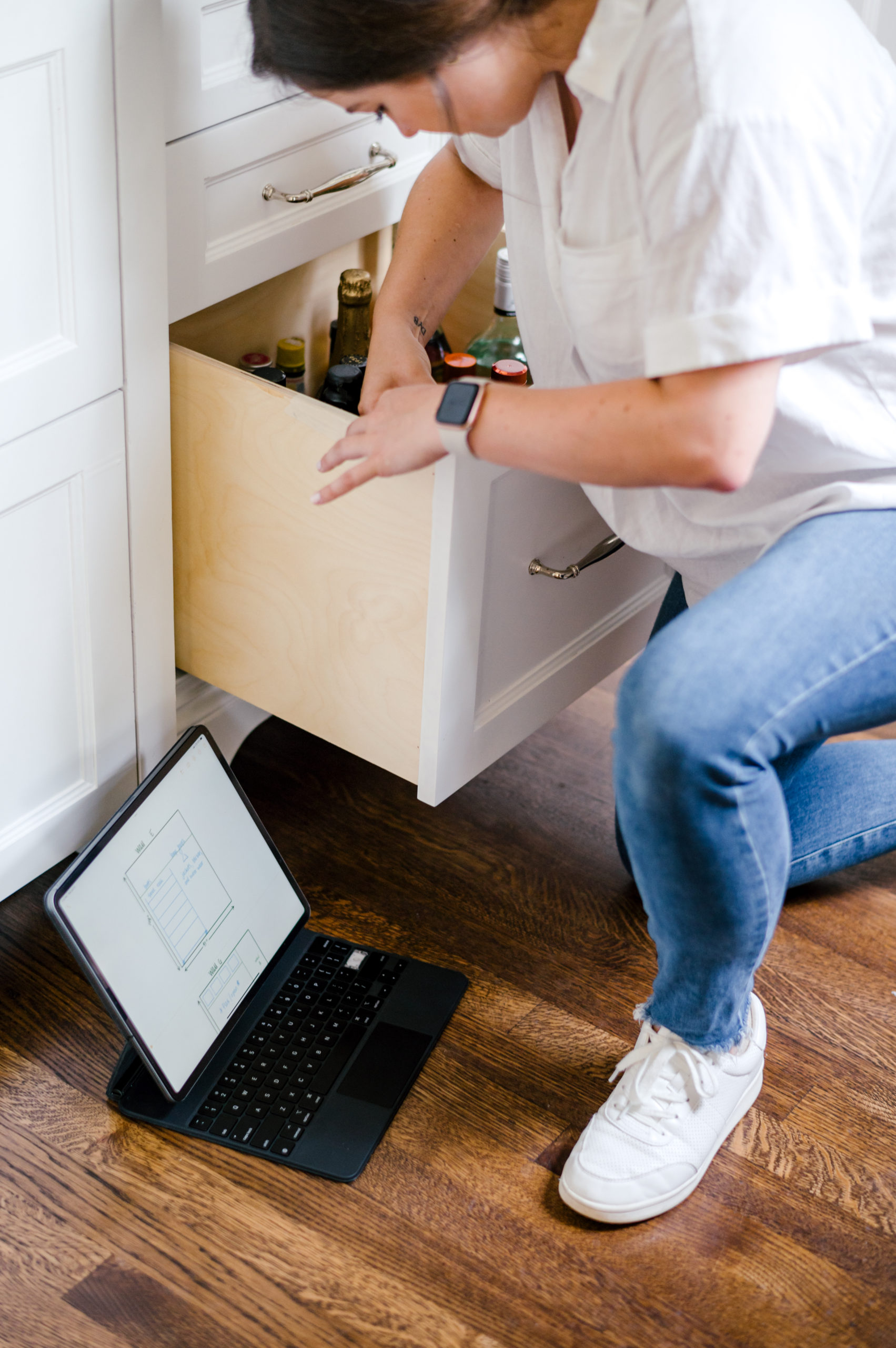 Woman organizing kitchen drawer full of alcoholic beverages