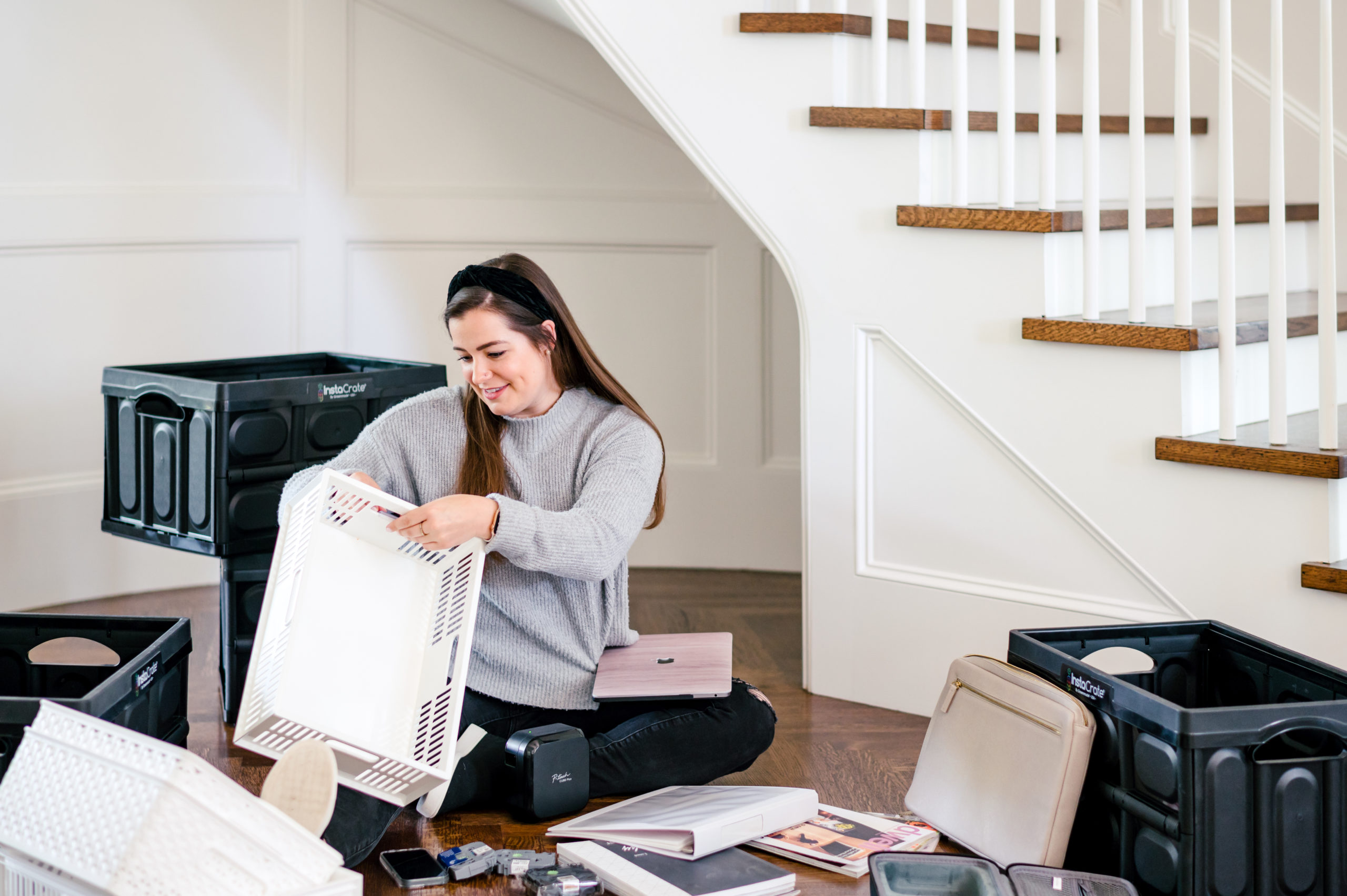 Woman sitting on hard wood floor organizing boxes and files