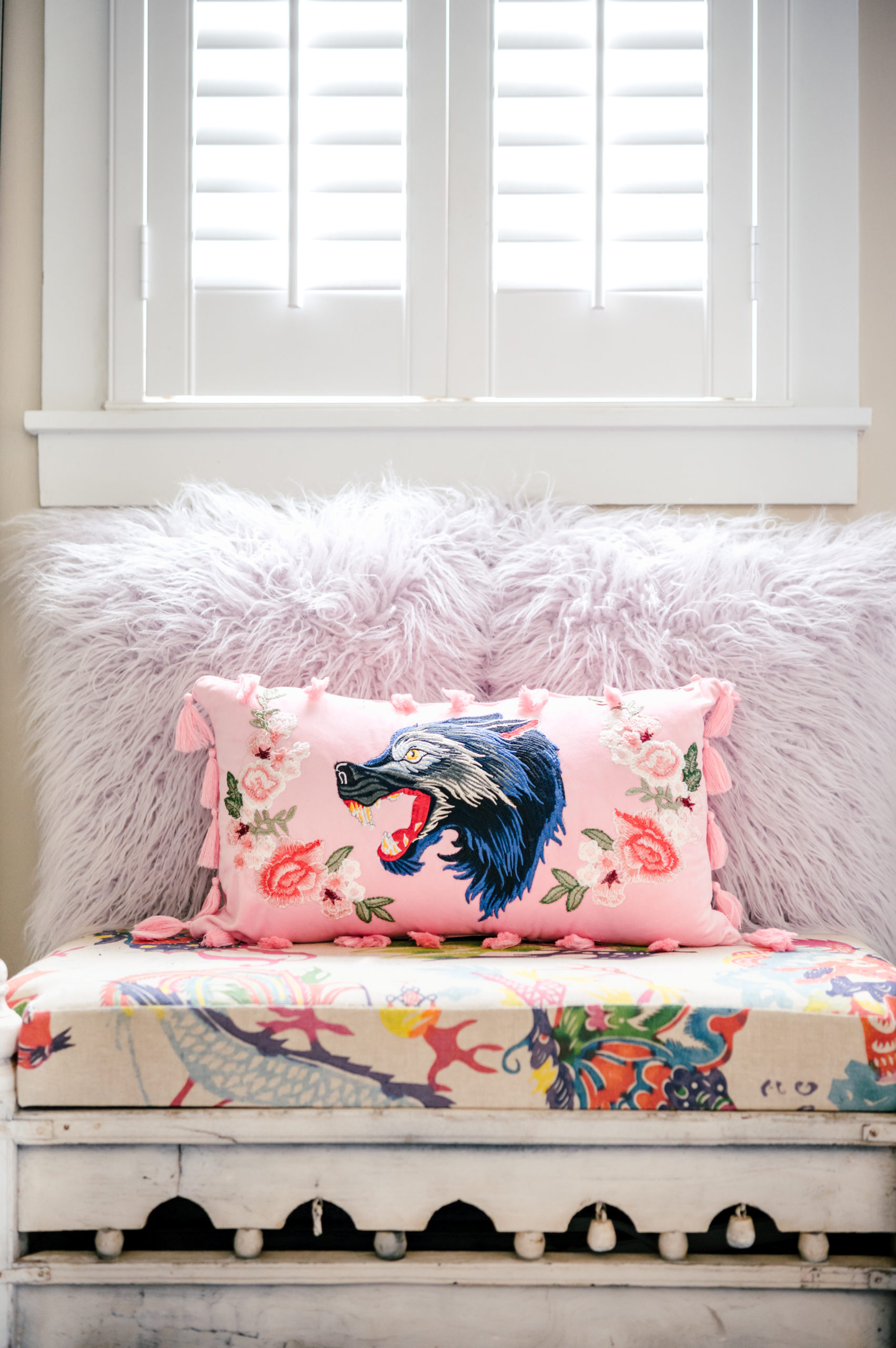 Pink pillow with the face of a wolf and flowers