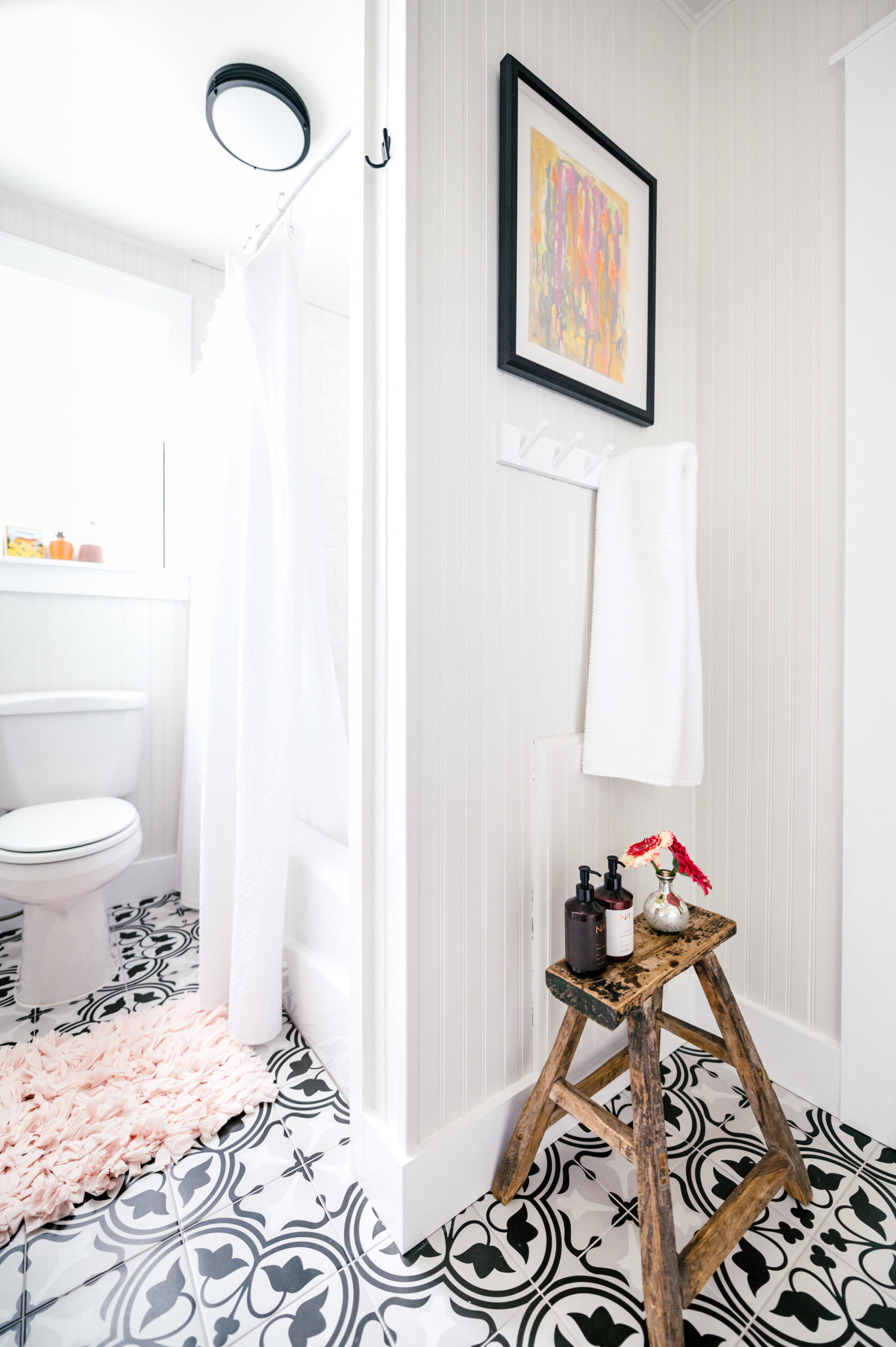 Short-term Rental Photos of bathroom interior with small wooden table and toilet on checkered floor