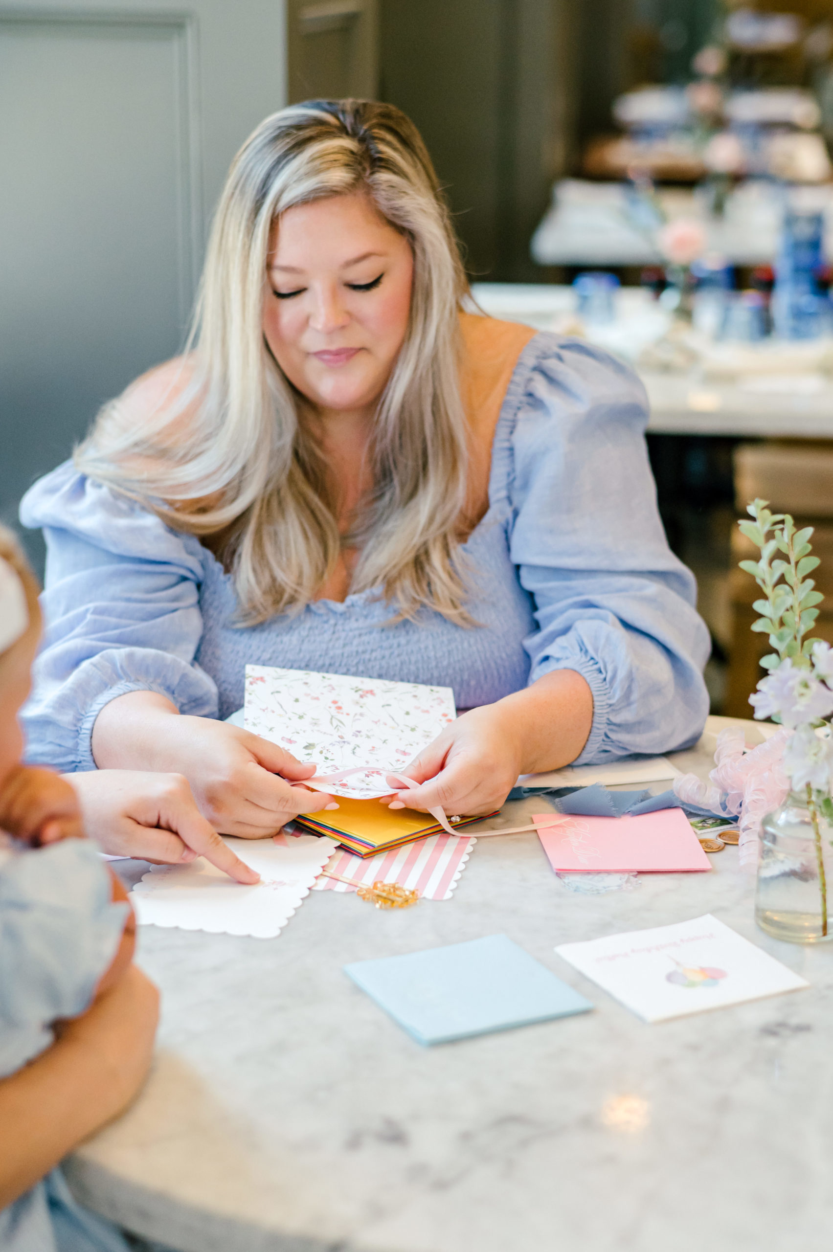 Woman making paper invitations for her etsy shop 