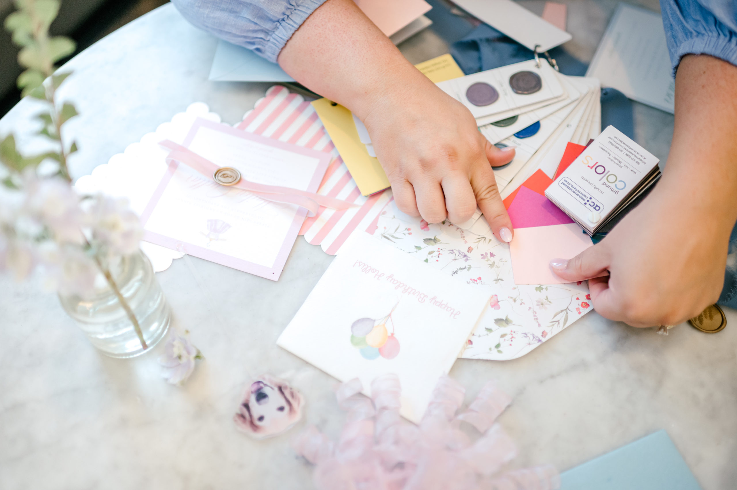 Woman hands putting together paper invitations for brand photoshoot