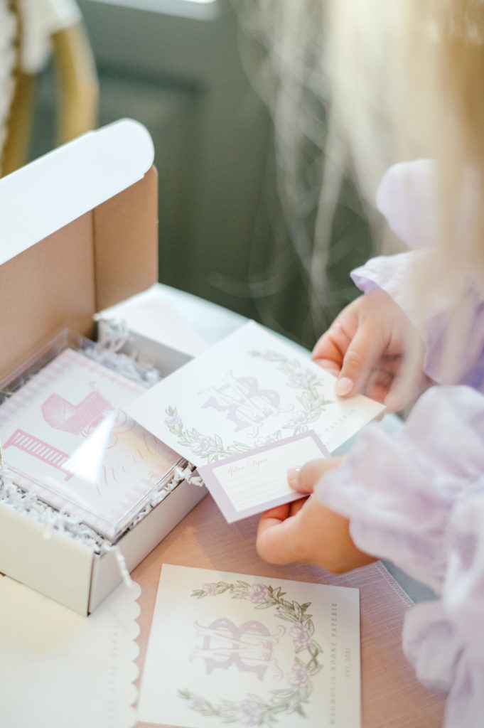 Woman making a gift box full of milestone cards and stationary