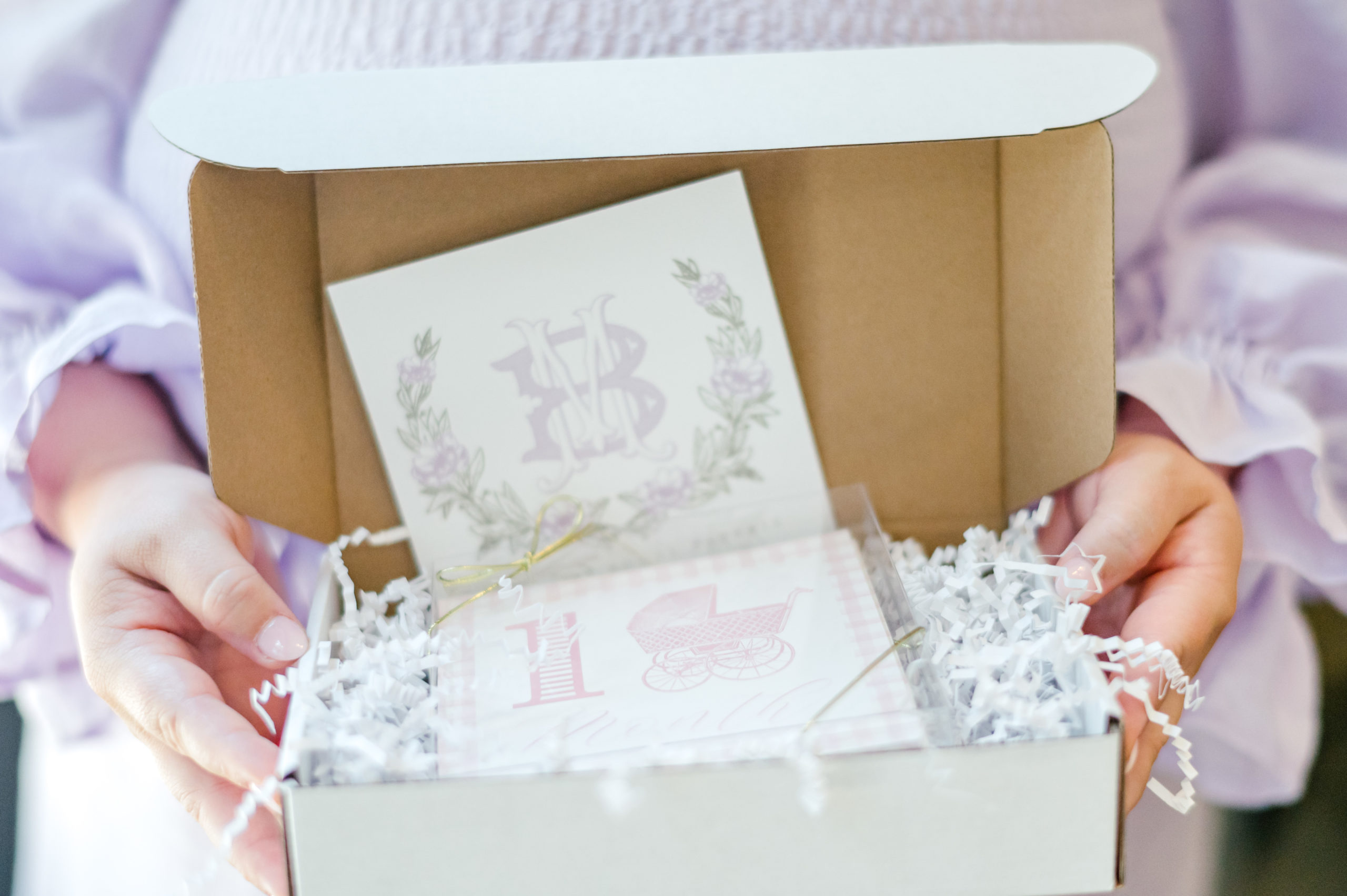 Woman holding a gift box full of milestone cards and stationary