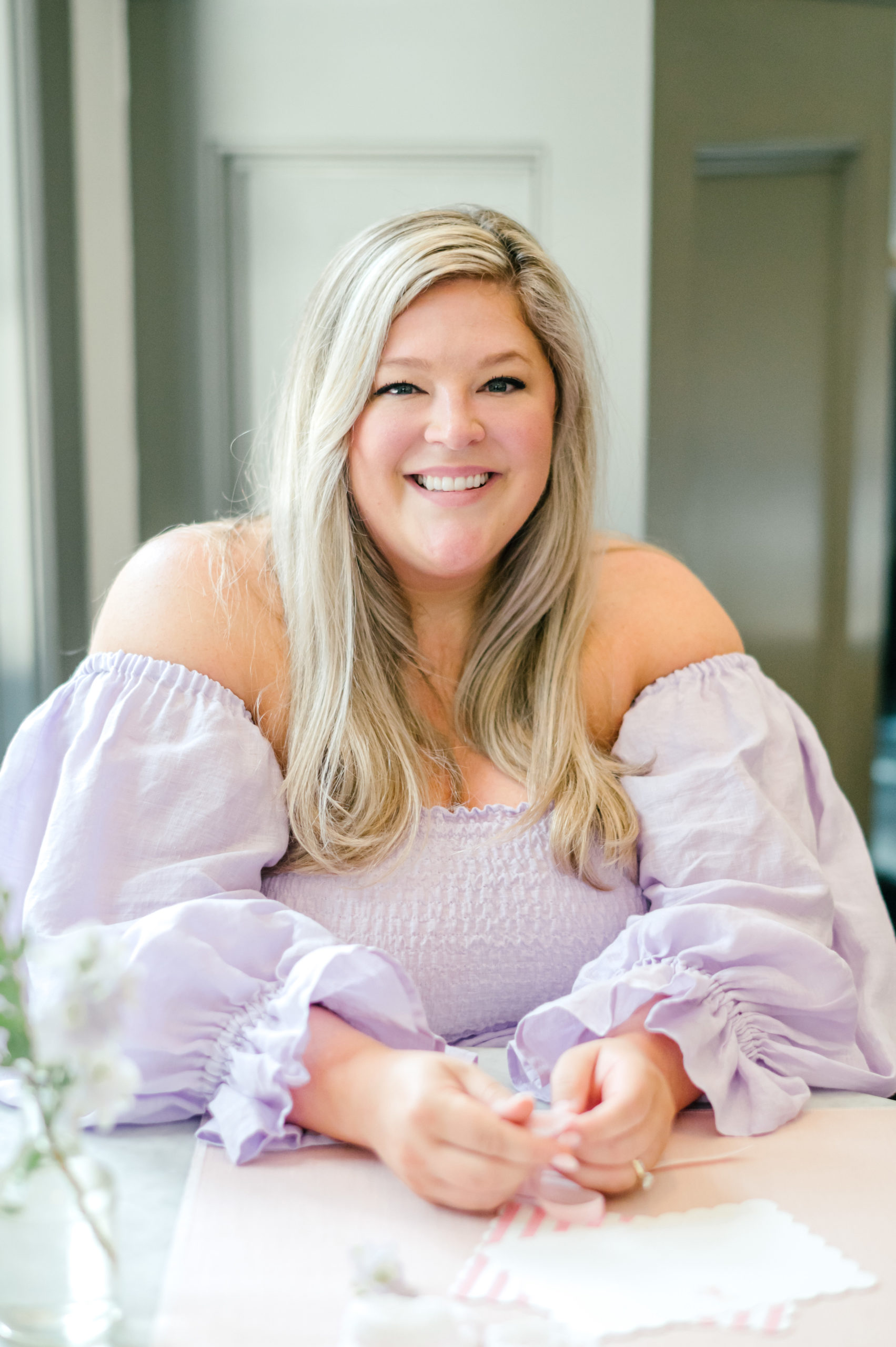 Woman smiling in a off the shoulder purple dress for her brand photoshoot