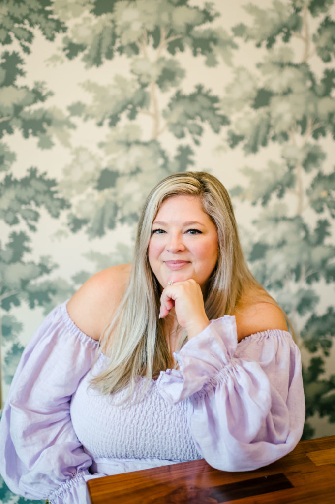 Woman smiling resting head on her fist posing for her brand photoshoots