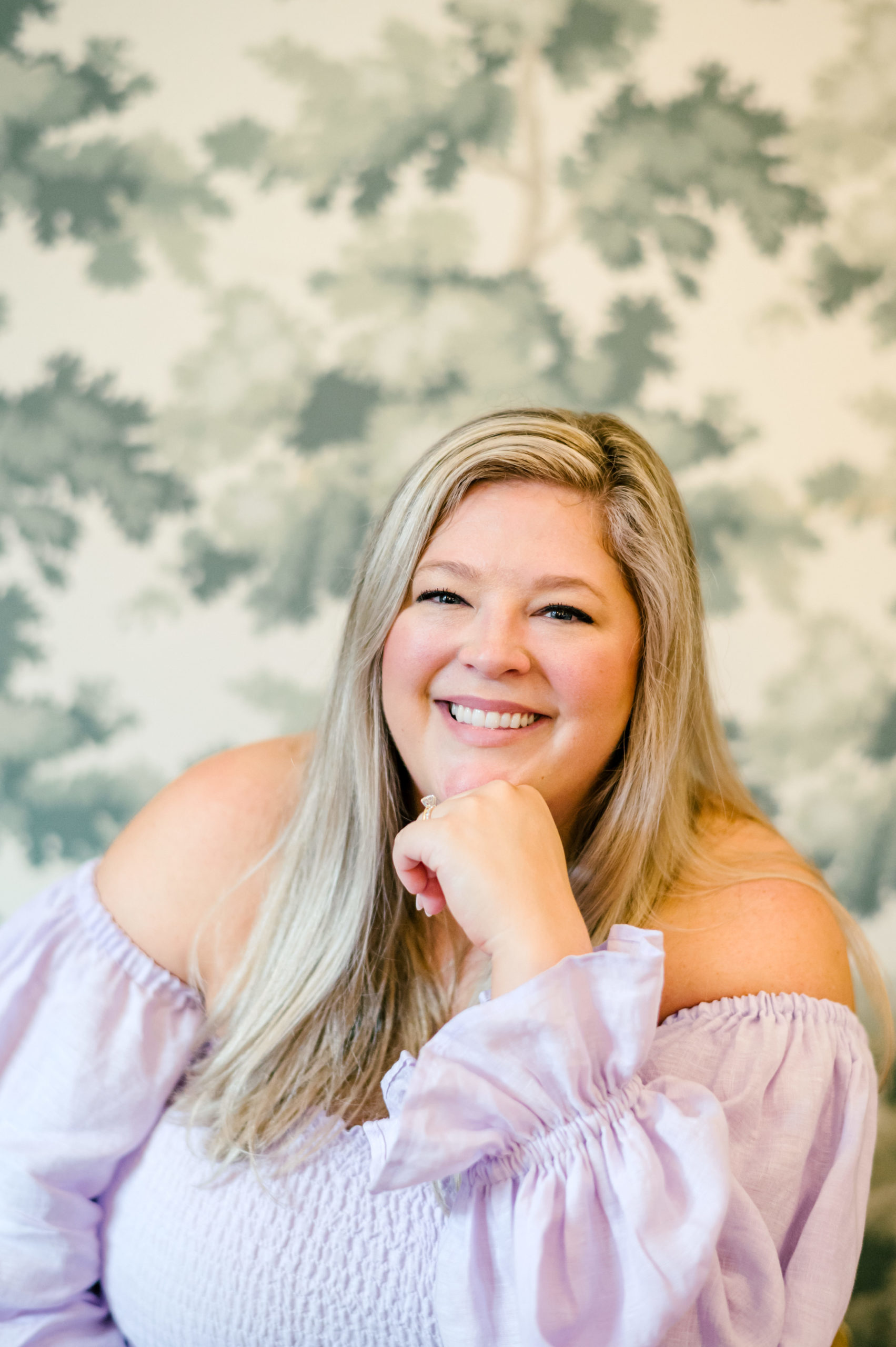 Woman smiling resting head on her fist posing for her brand photoshoots