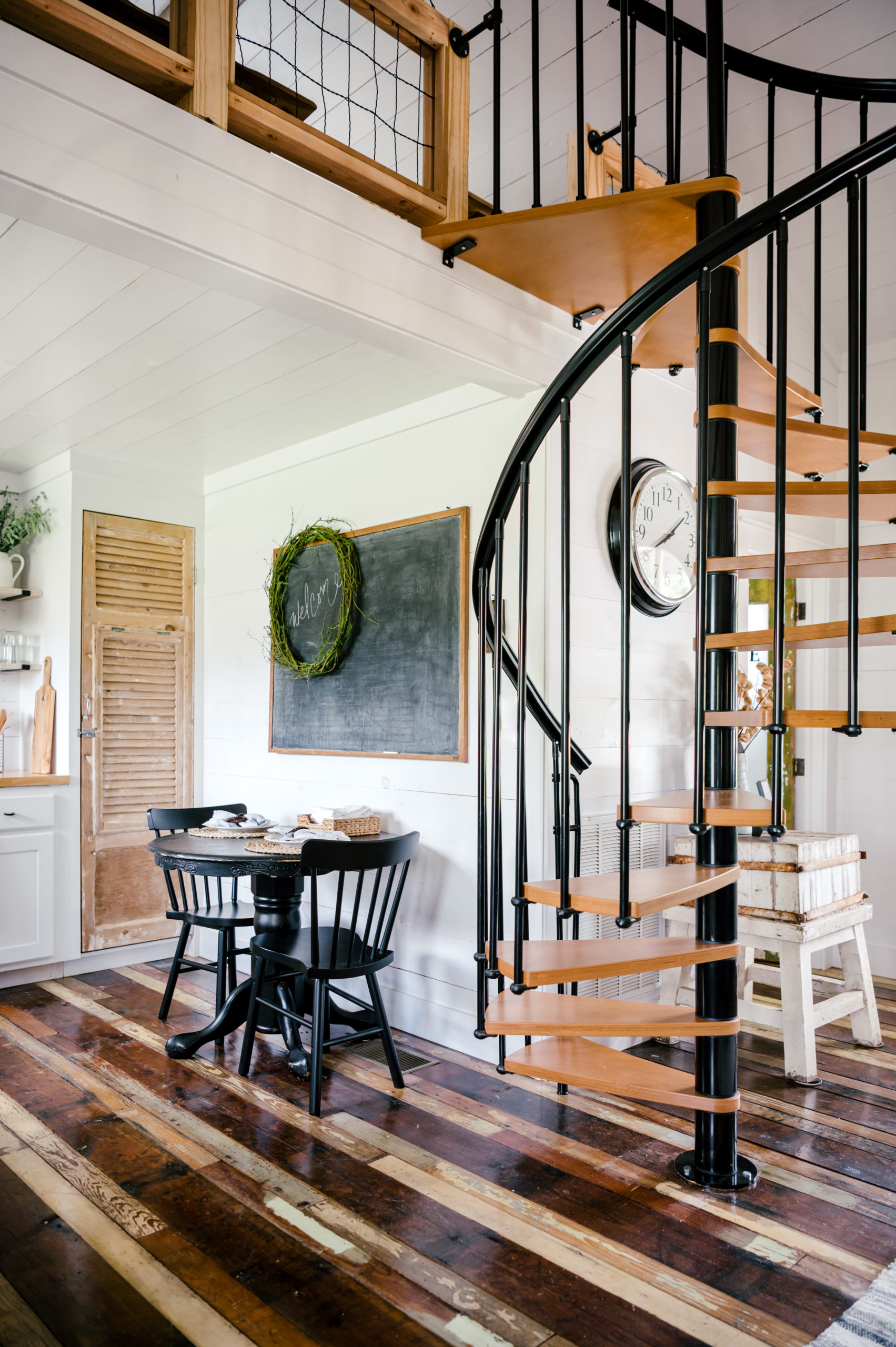 Airbnb photography of dining room chair and tables next to staircase that goes upstairs