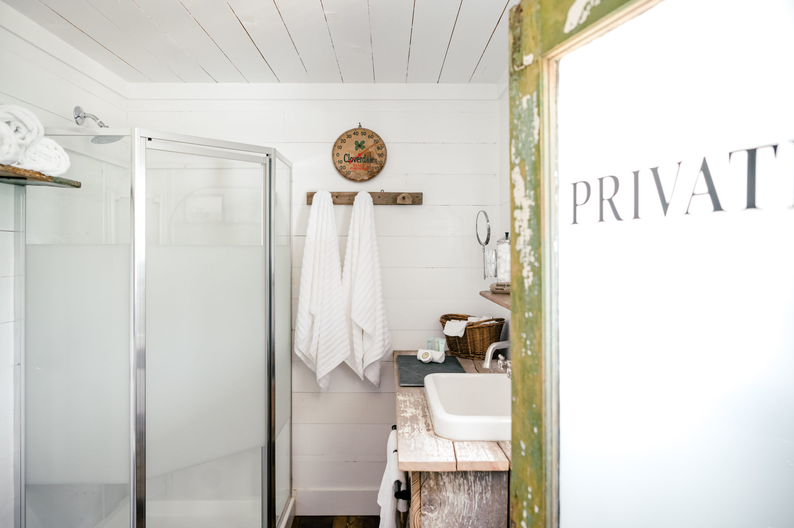 Shower with towels hanging and rustic wooden sink 