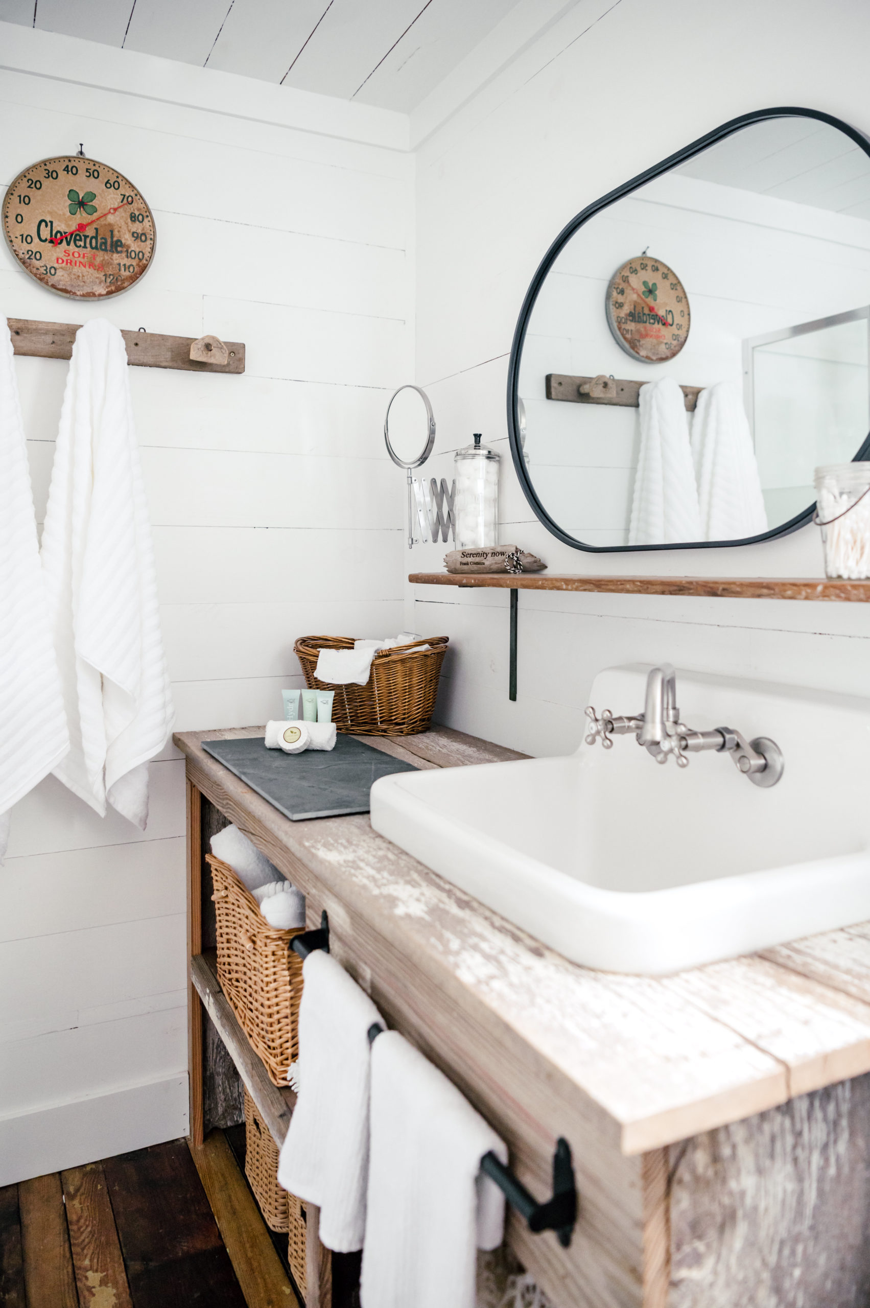 Rustic wooden sink and counter with circular bathroom mirror