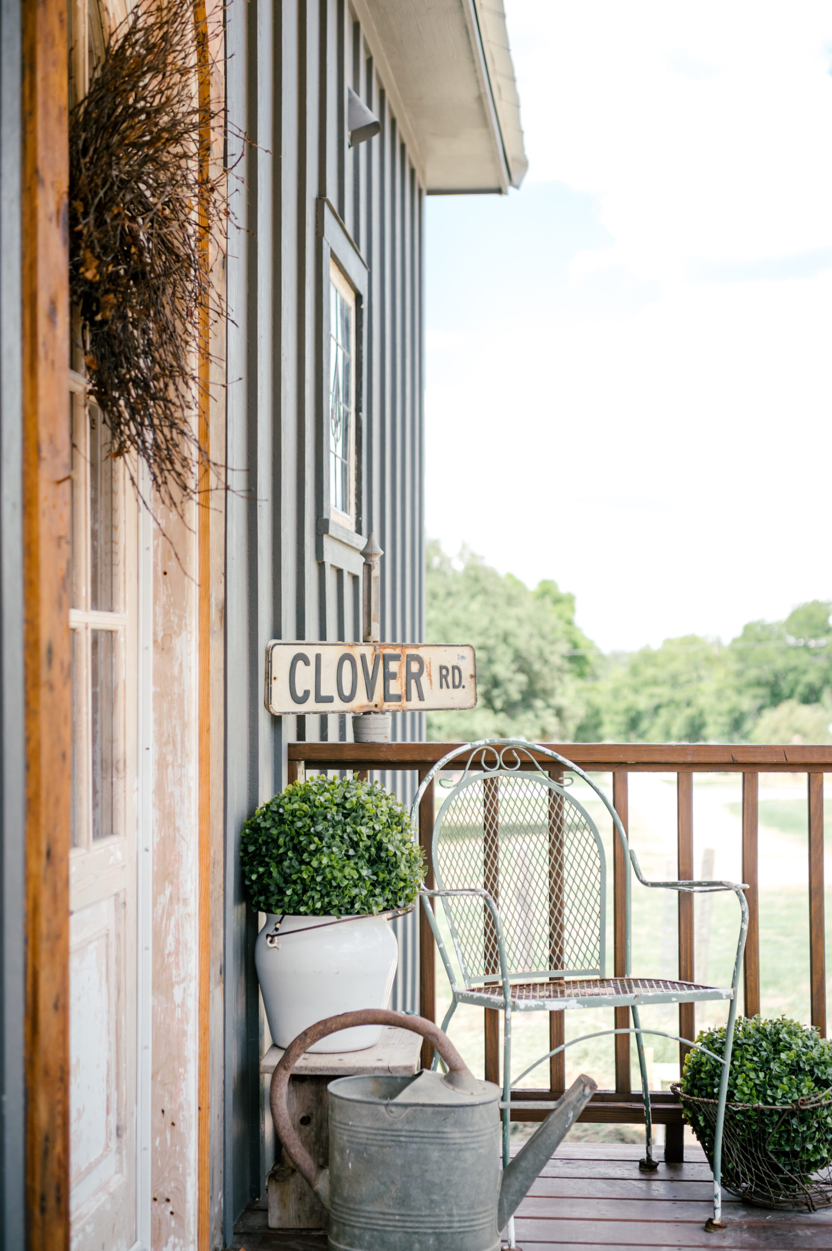 Airbnb photography of metal chair, plants on a wooden porch 