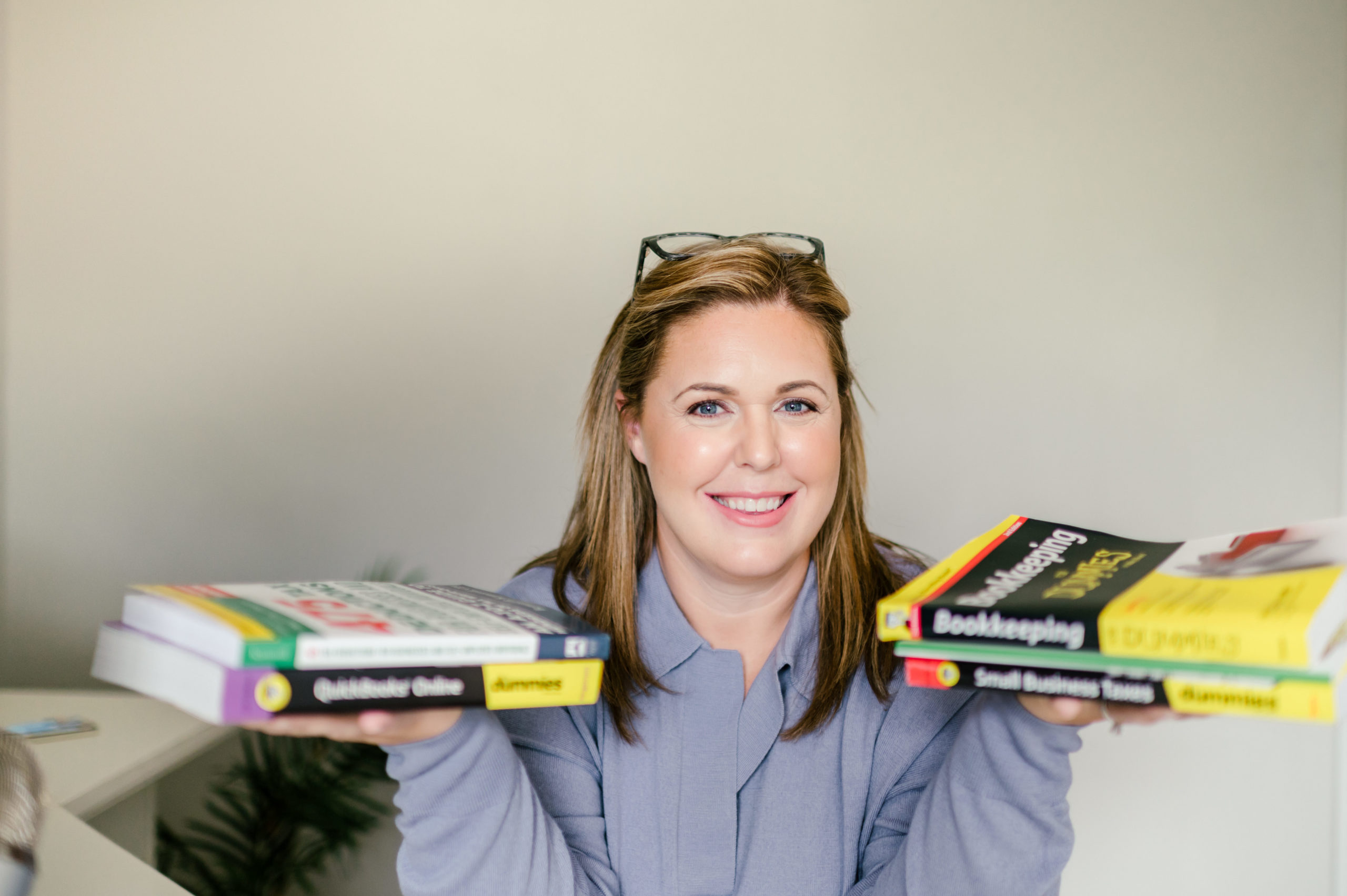 CPA business woman holding two accountant books in each hand smiling for her Small Business Branding Photography 