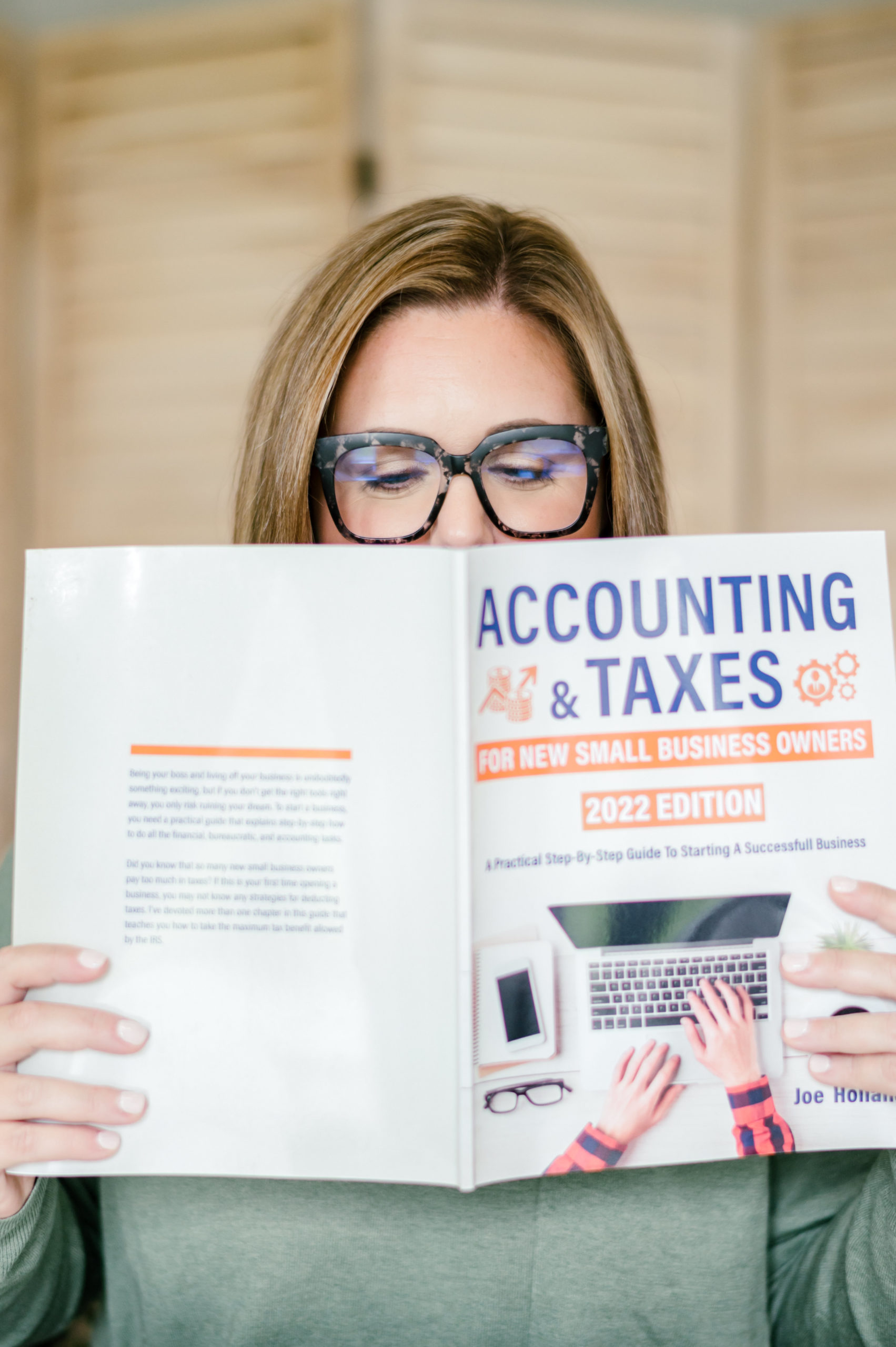 Small Business Branding Photography  of CPA business woman holding up accounting and taxes book cover her face
