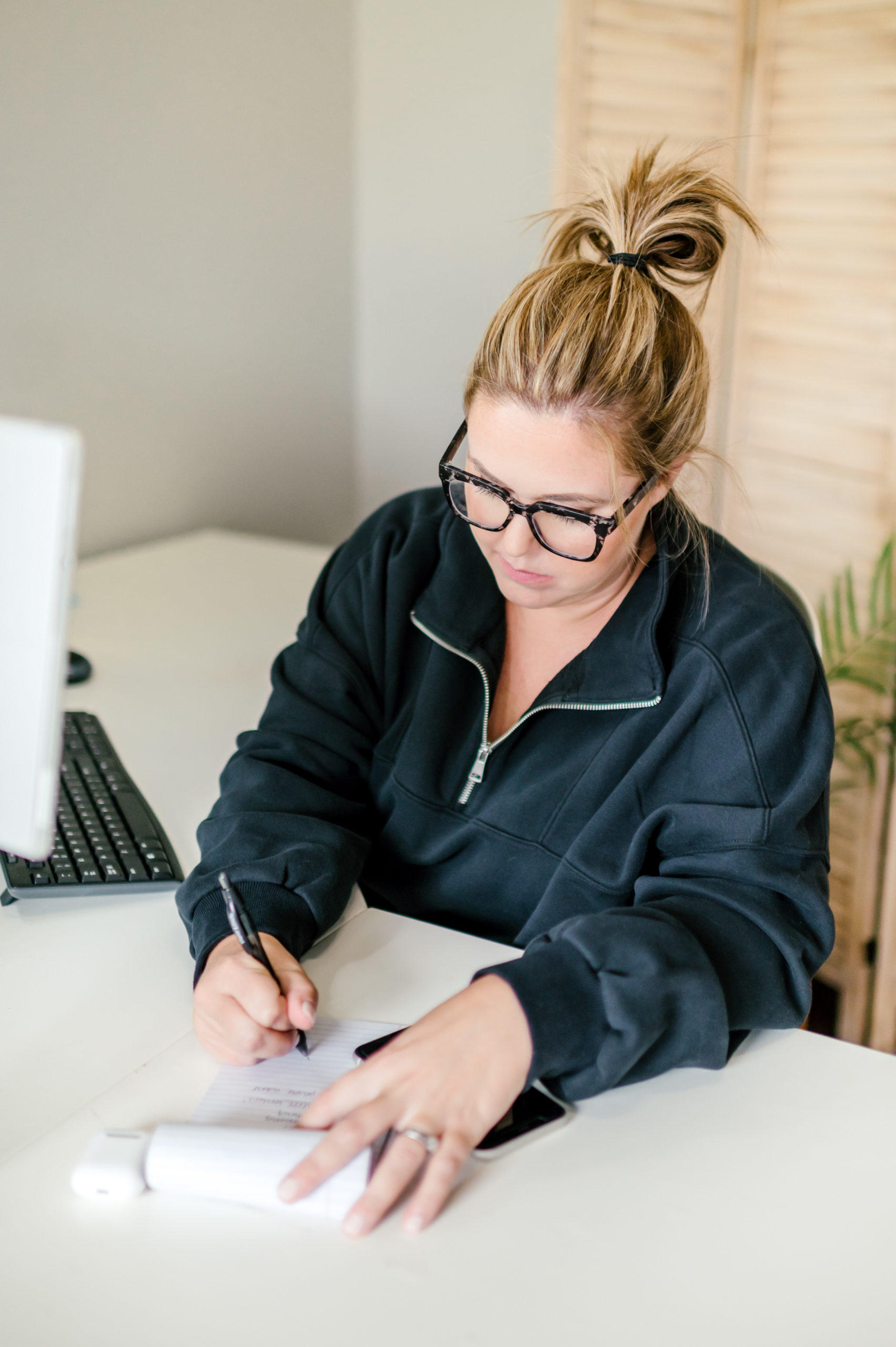 Woman accountant writing on a notepad in her office 