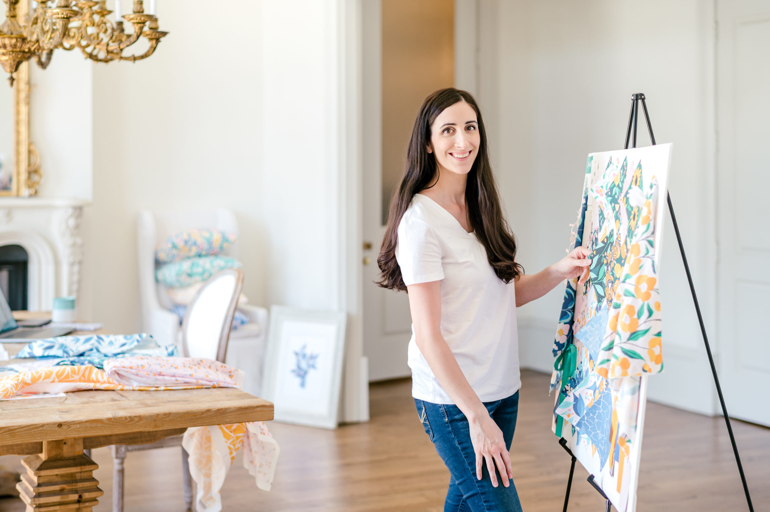 Woman designer smiling standing next to a board of her design patterns for her branding session