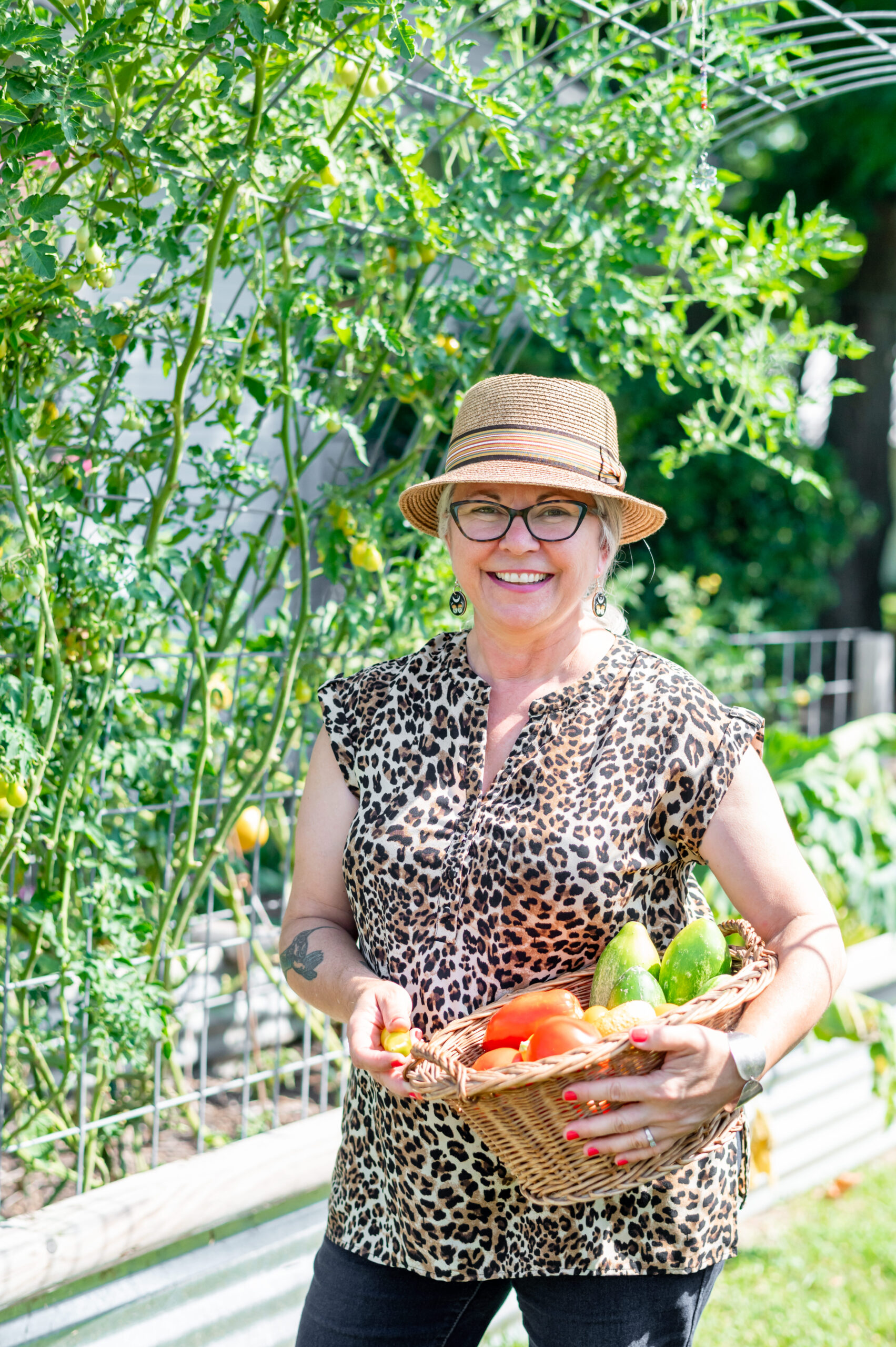 Woman smiling holding a basket full of vegetables