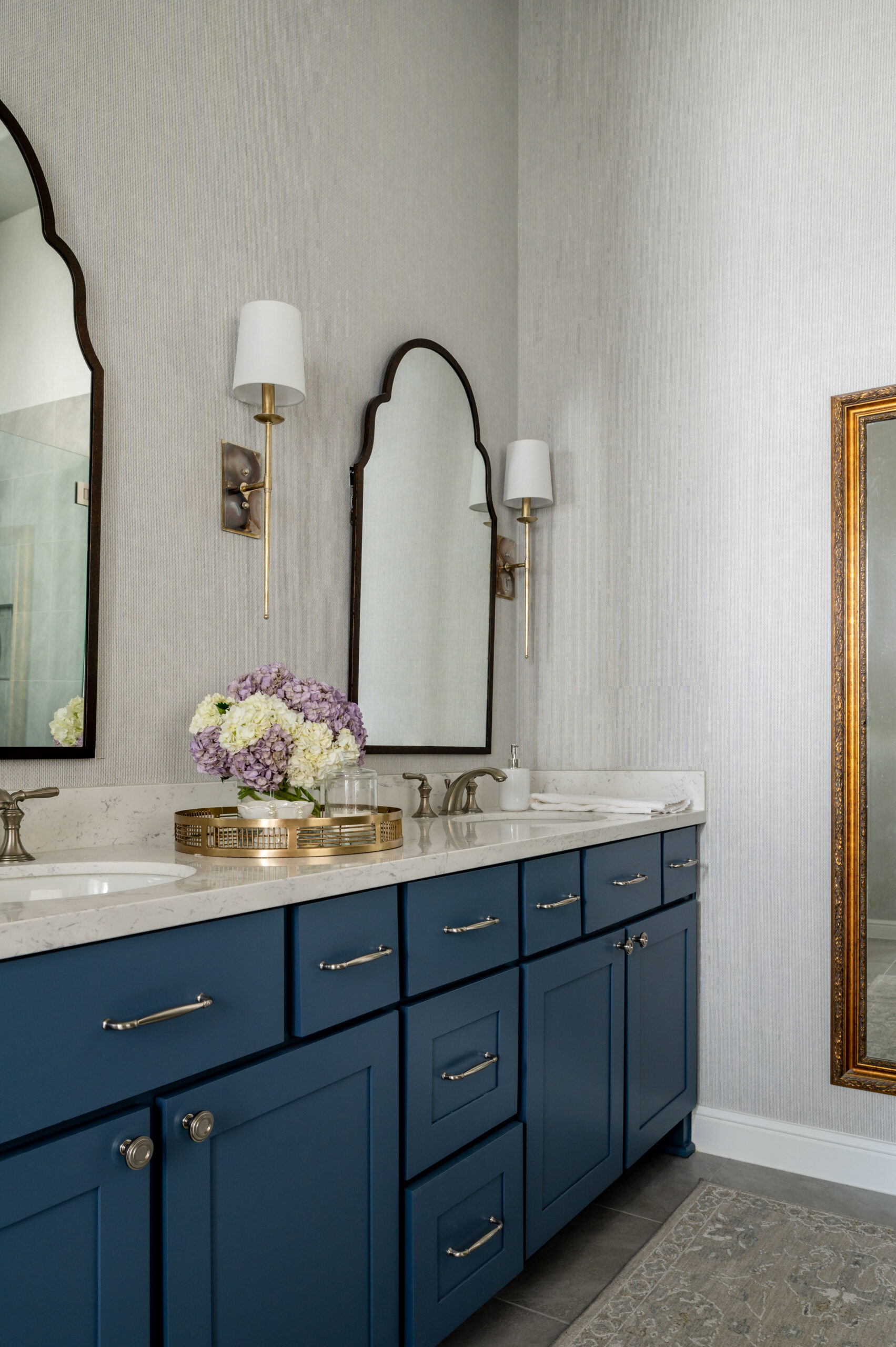 Gorgeous bathroom interior design with blue cabinets and marble counters