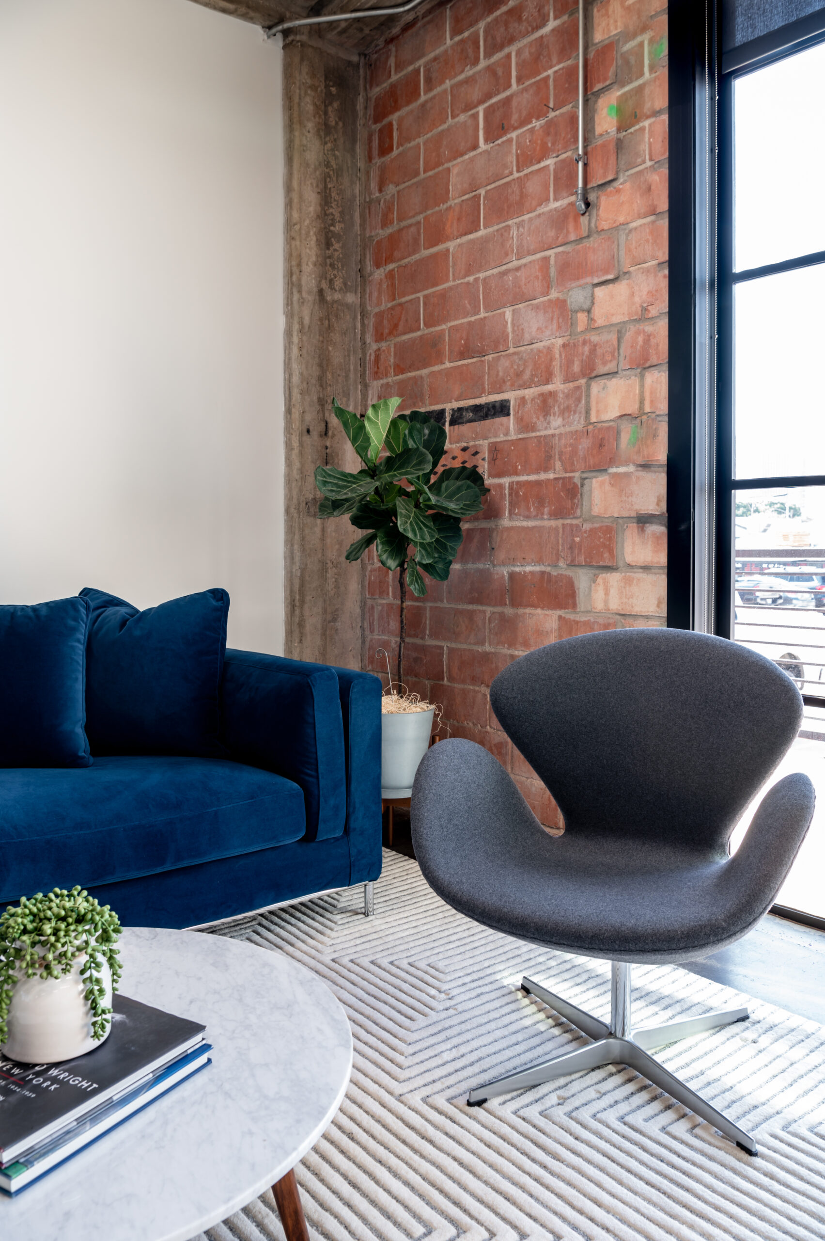 Office space with blue couch and brick walls