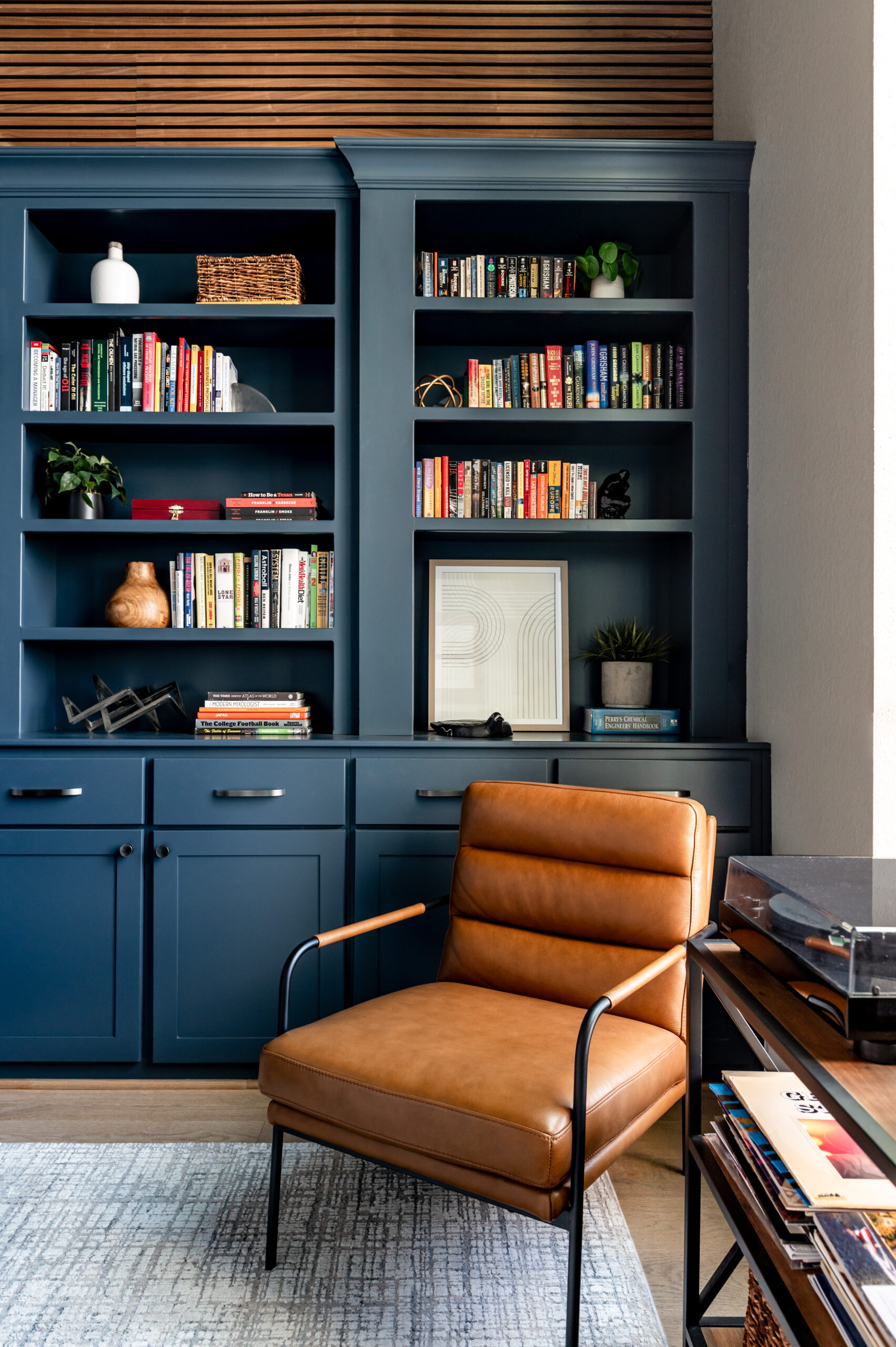 Office interior design with blue book shelf and leather chair