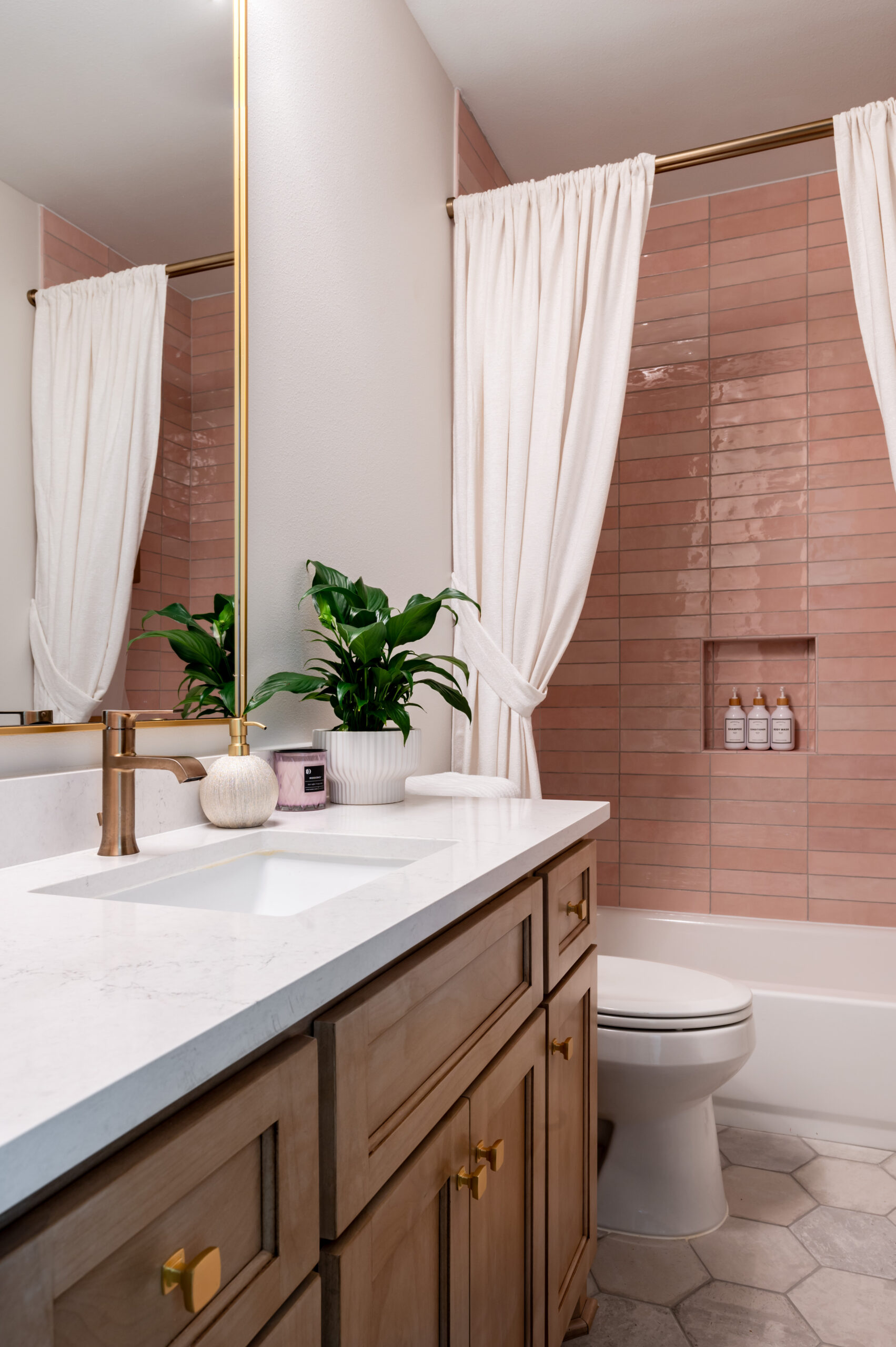 Bathroom interior with marble counters and pink shower backsplash