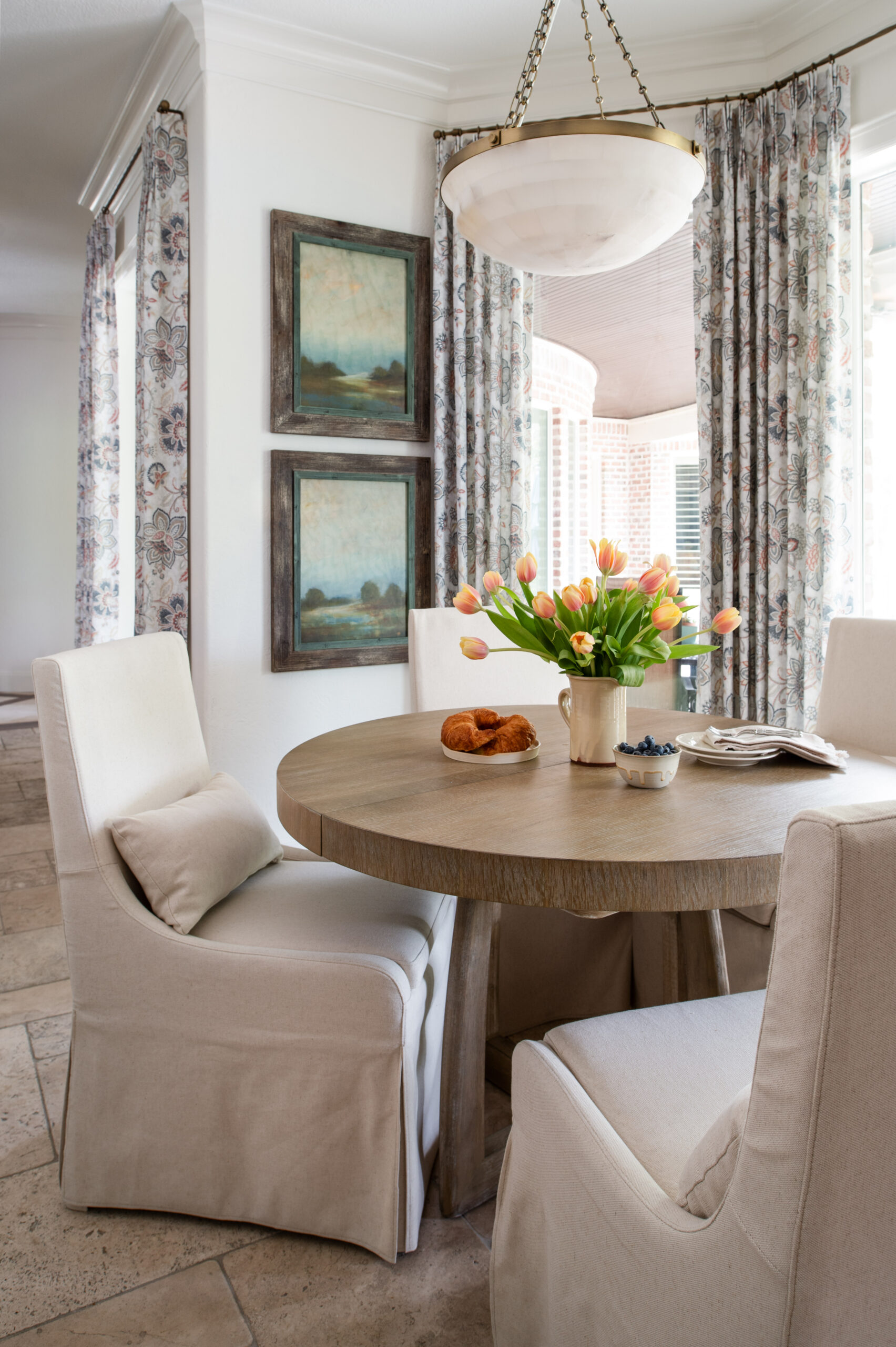 Beautiful interior design photos of a dining room table with a croissant and bowl of blueberries