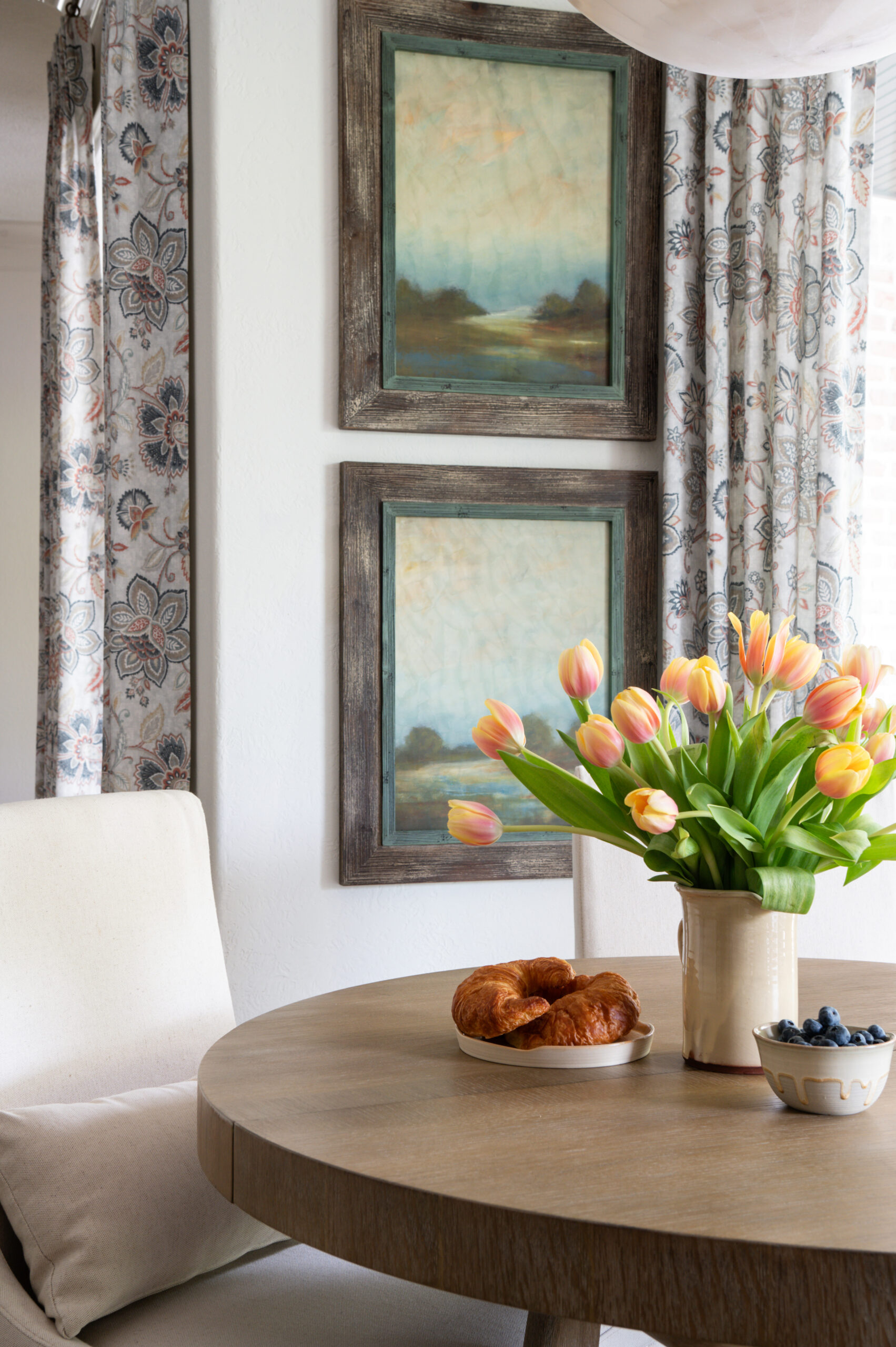 Beautiful interior design photos of a dining room table with a croissant and bowl of blueberries